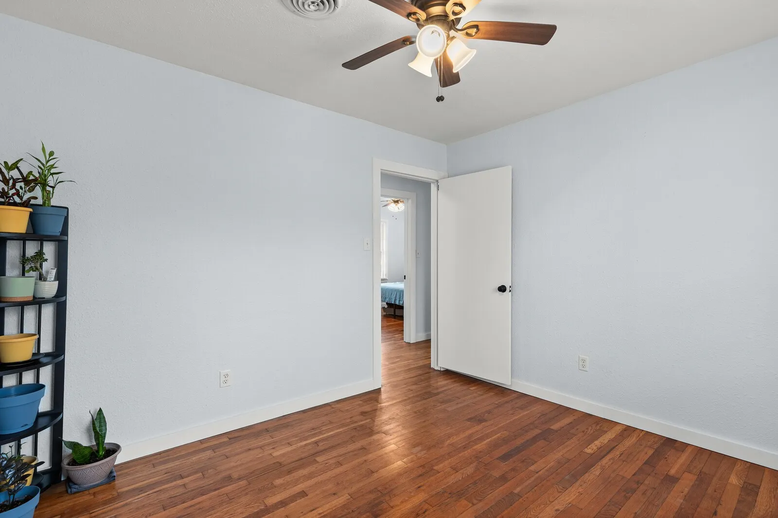 Empty room with hardwood / wood-style floors and ceiling fan
