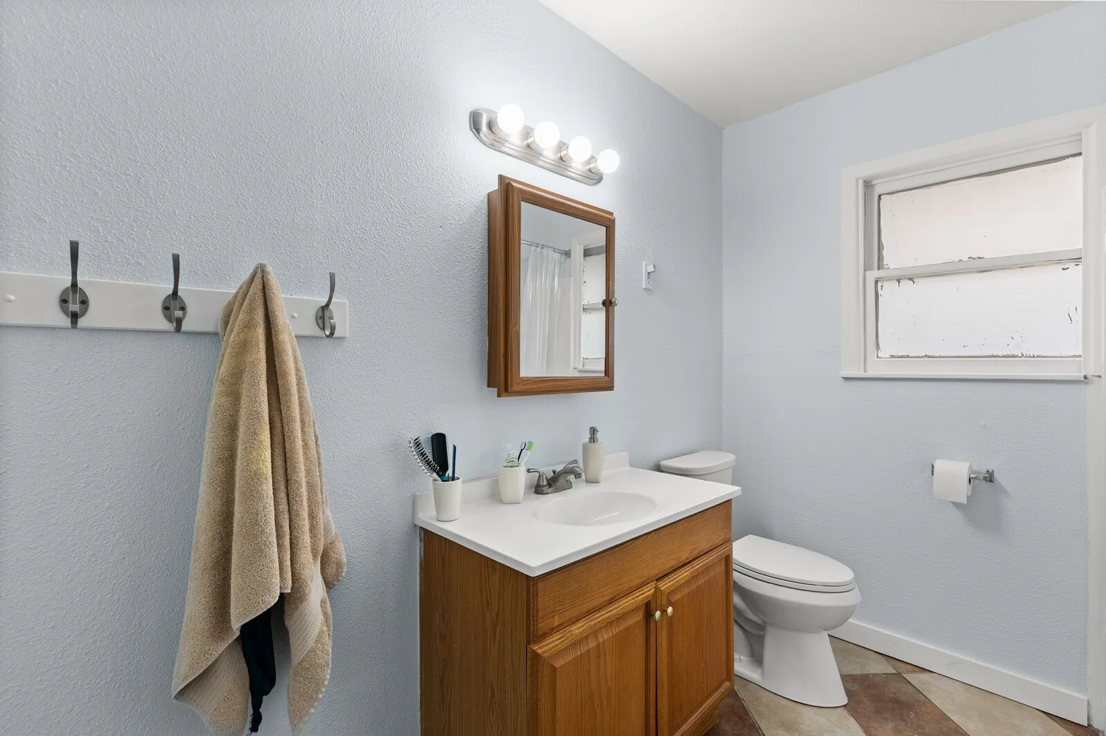Full bathroom with vanity, curtained shower, and light tile patterned floors
