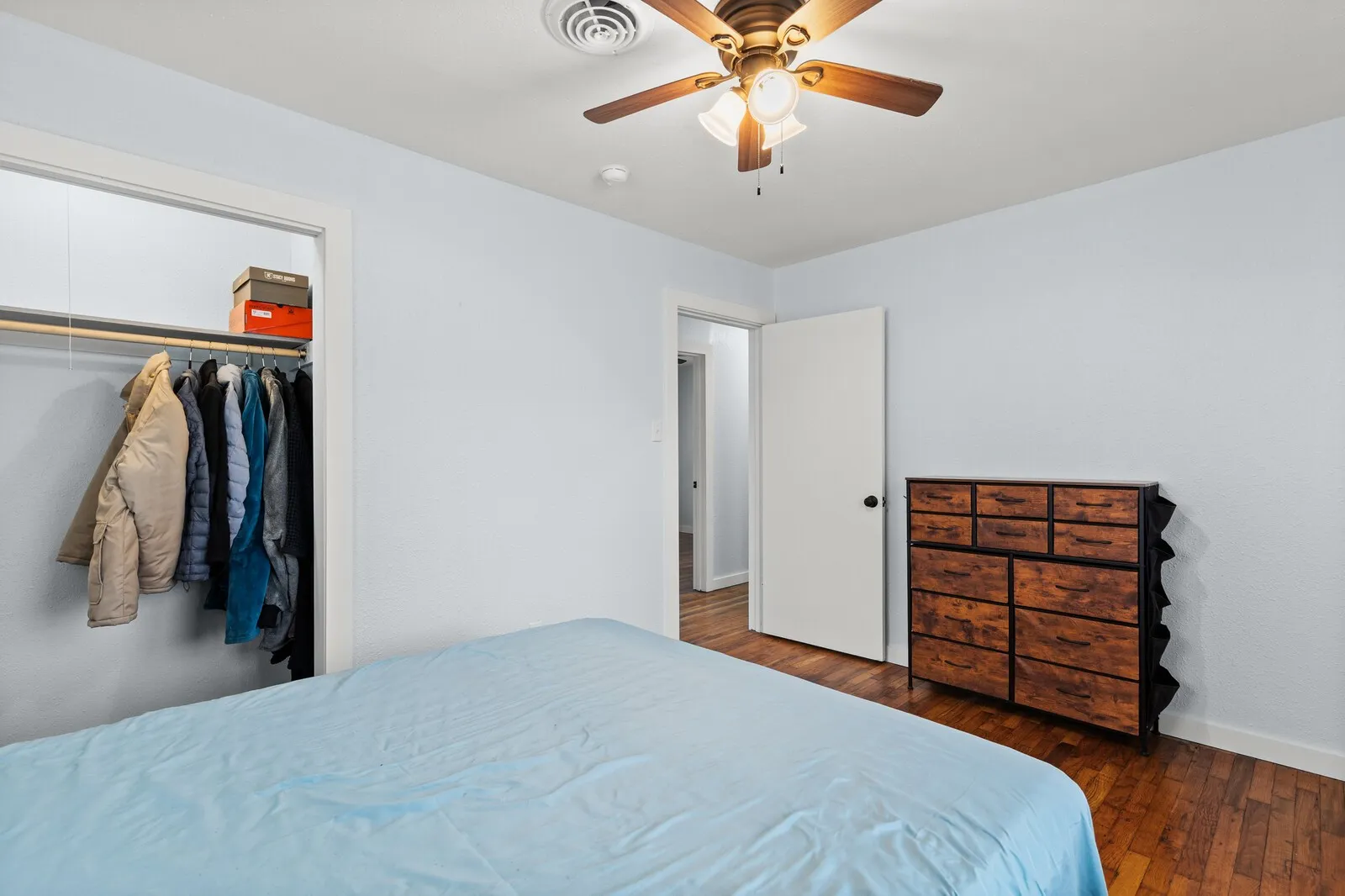 Bedroom featuring ceiling fan, dark wood finished floors, and a closet