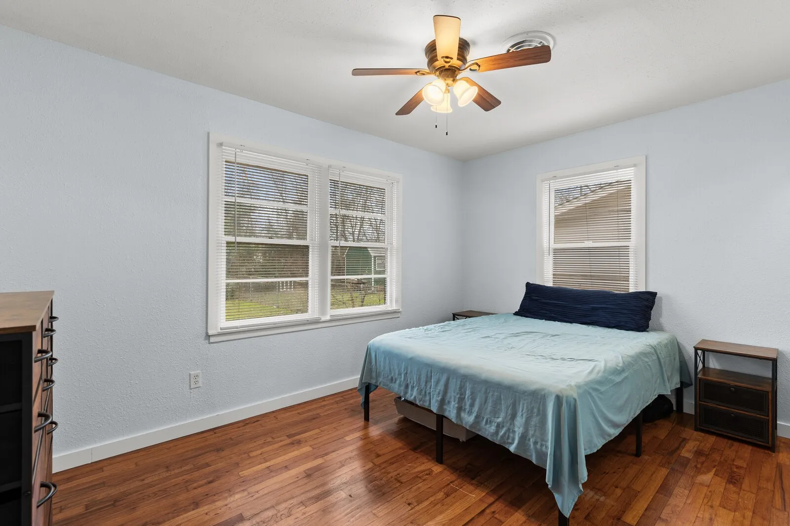 Bedroom with ceiling fan and dark wood finished floors