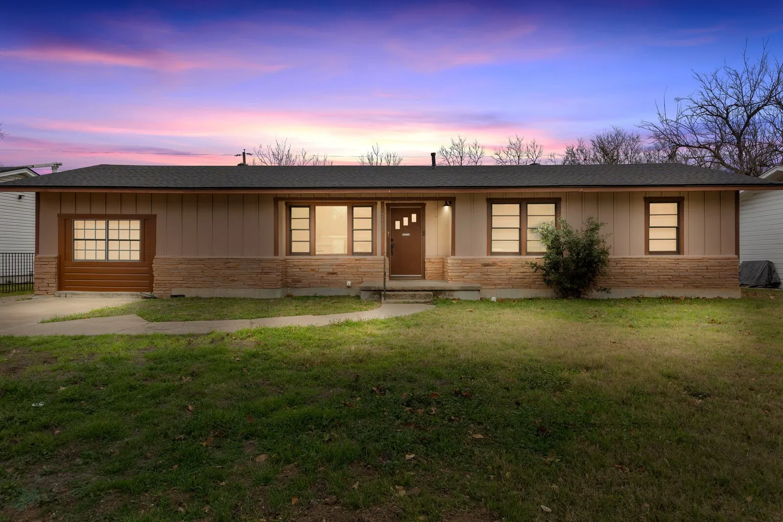View of front facade with a front lawn, board and batten siding, and a shingled roof (virtual twilight photo)
