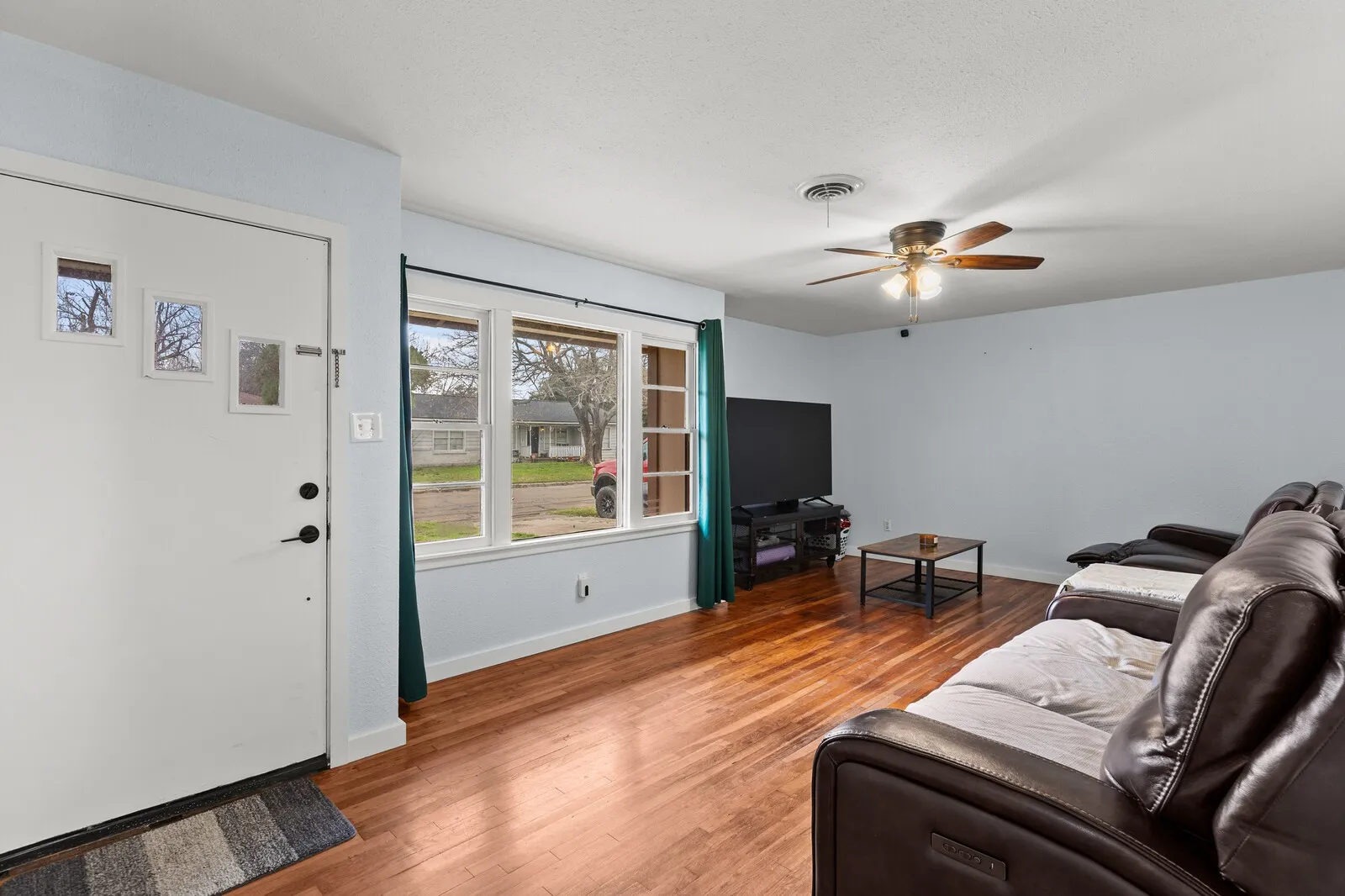 Living area with wood finished floors and a ceiling fan