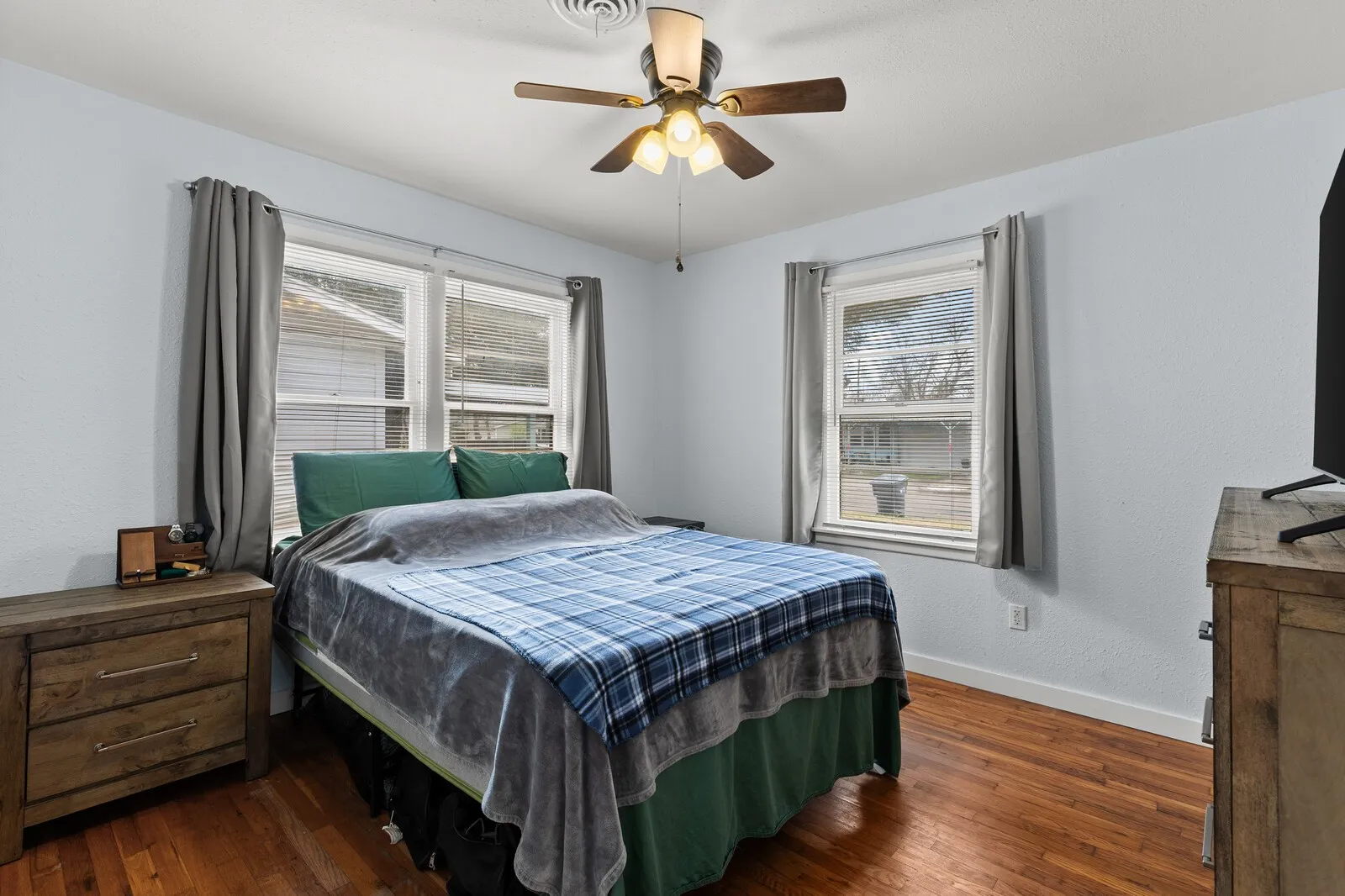 Bedroom with dark wood-style floors and a ceiling fan