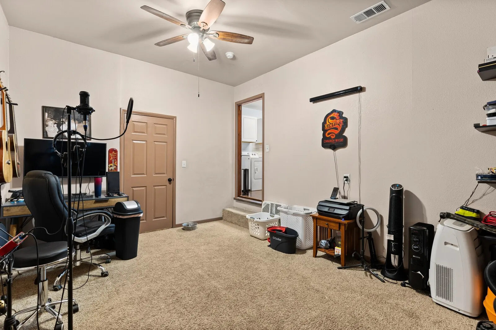 Office with light colored carpet, ceiling fan, and washer / dryer