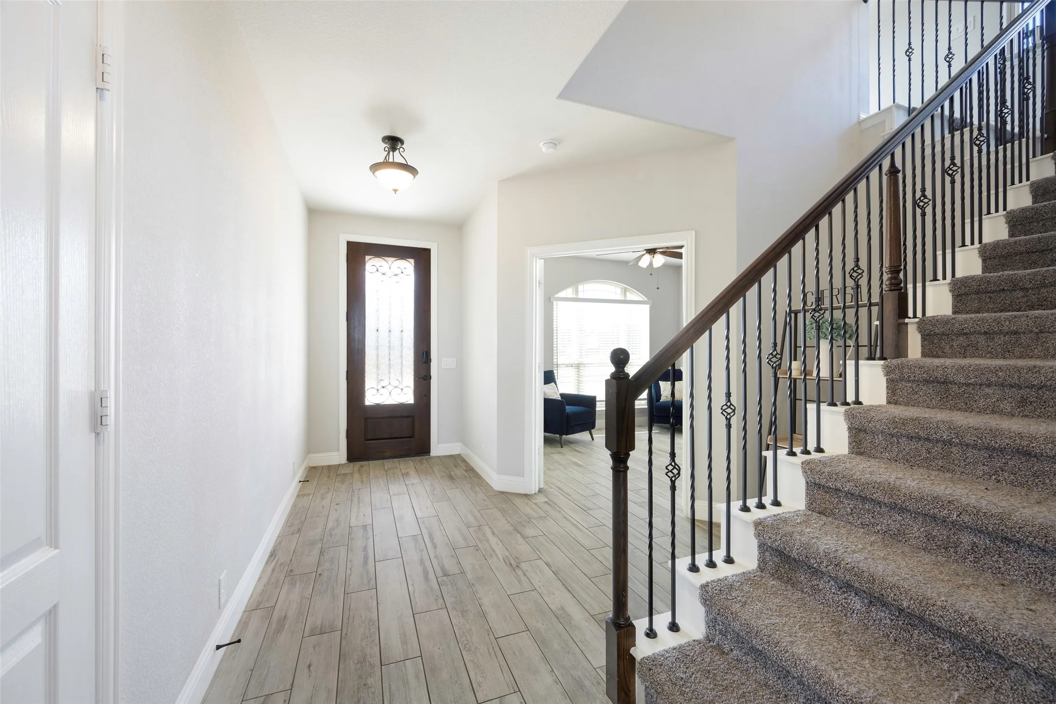 Entryway with wood tiled floors, stairs, and a ceiling fan