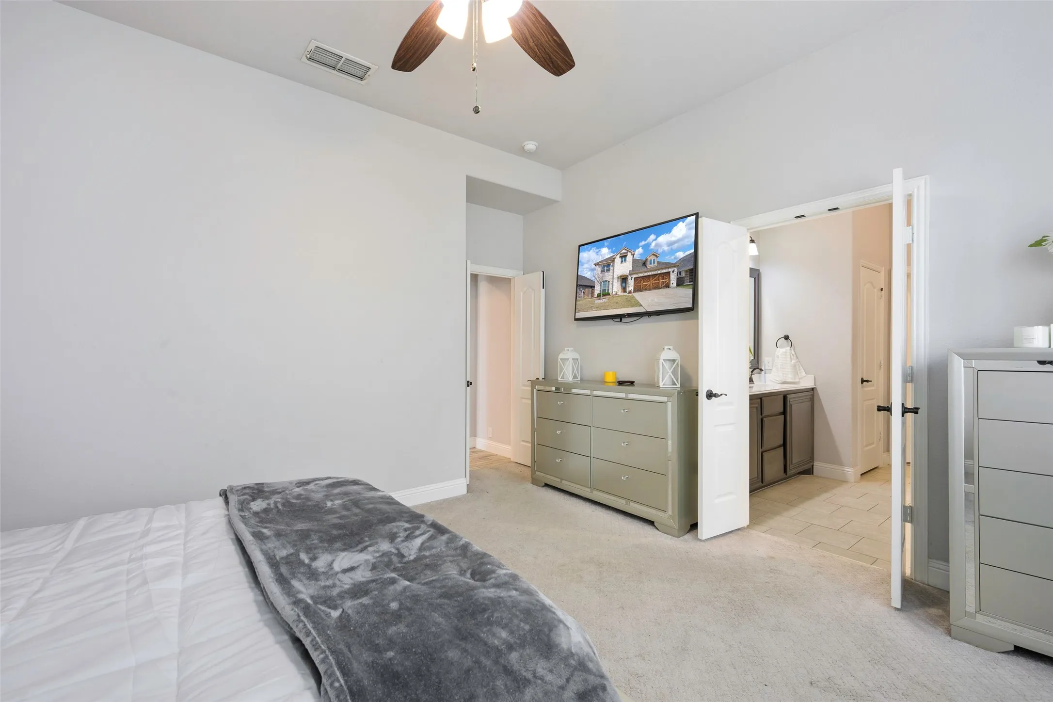 Bedroom with light carpet and a ceiling fan