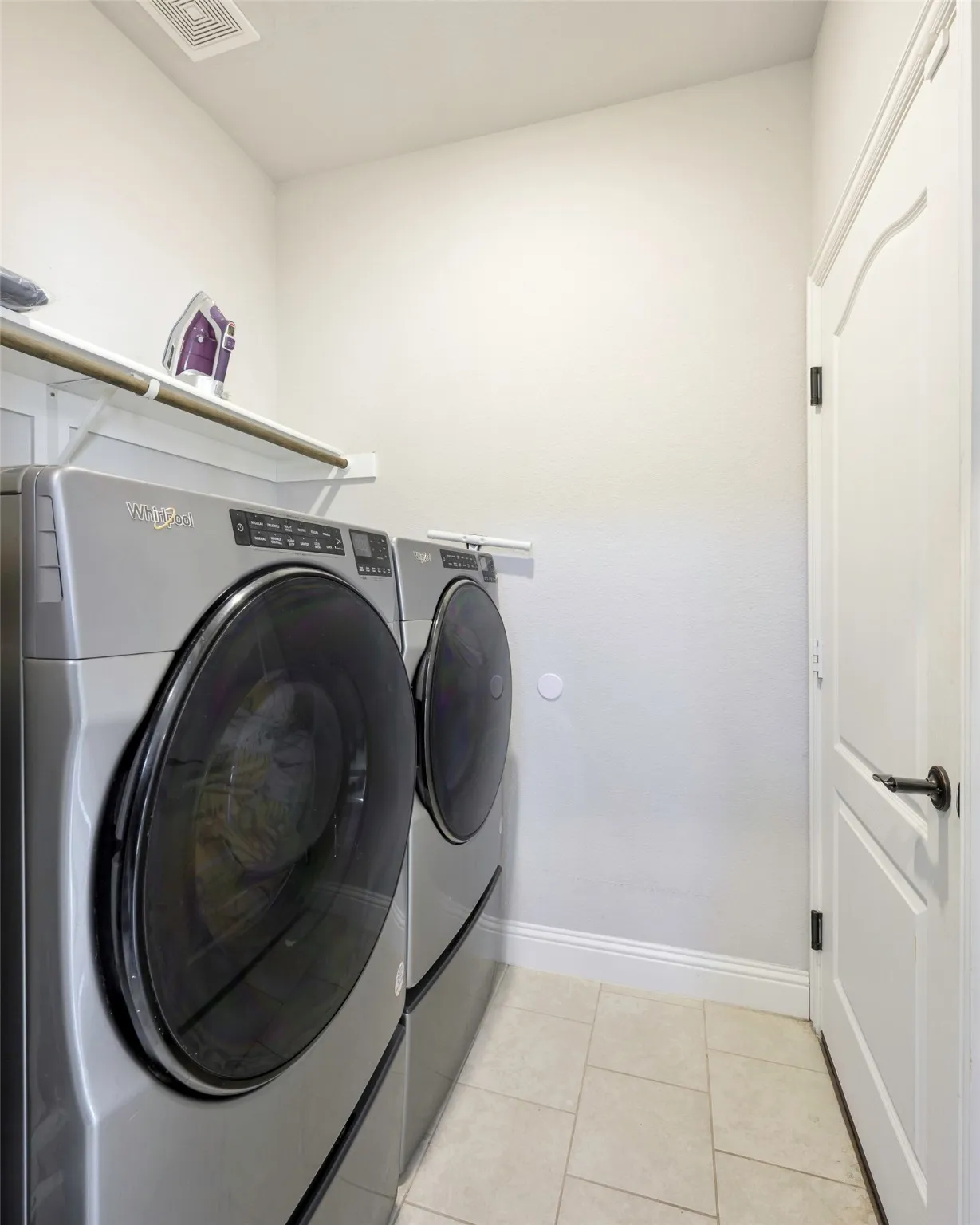 Laundry area featuring light tile patterned floors and washer and dryer