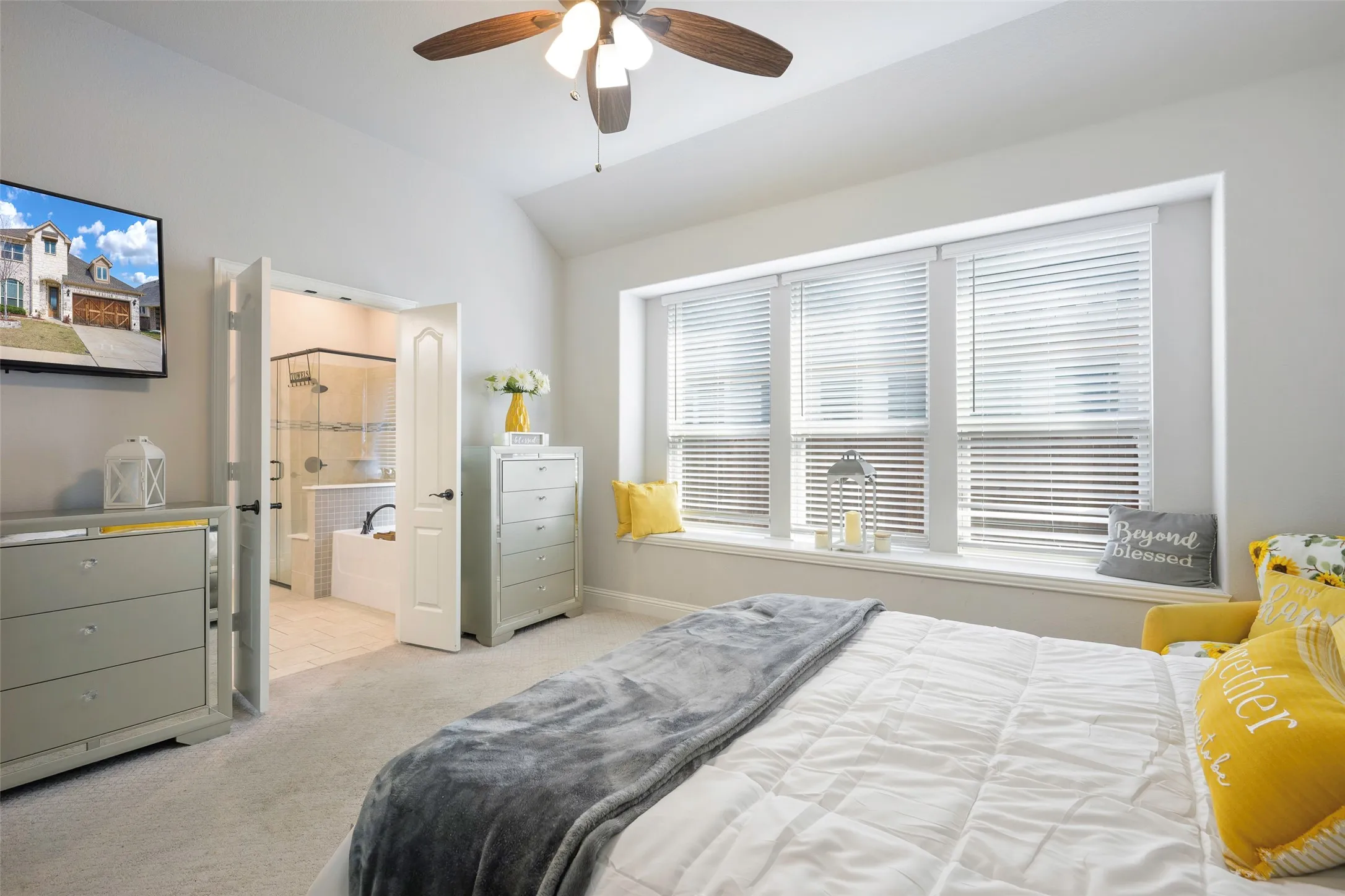 Bedroom featuring vaulted ceiling, light colored carpet, ceiling fan, and ensuite bathroom