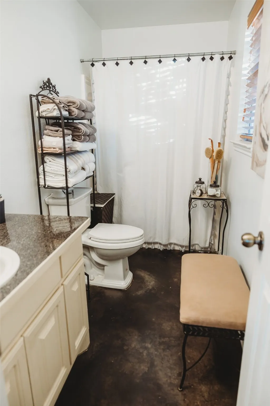Full bathroom with vanity, a shower with curtain, and concrete flooring