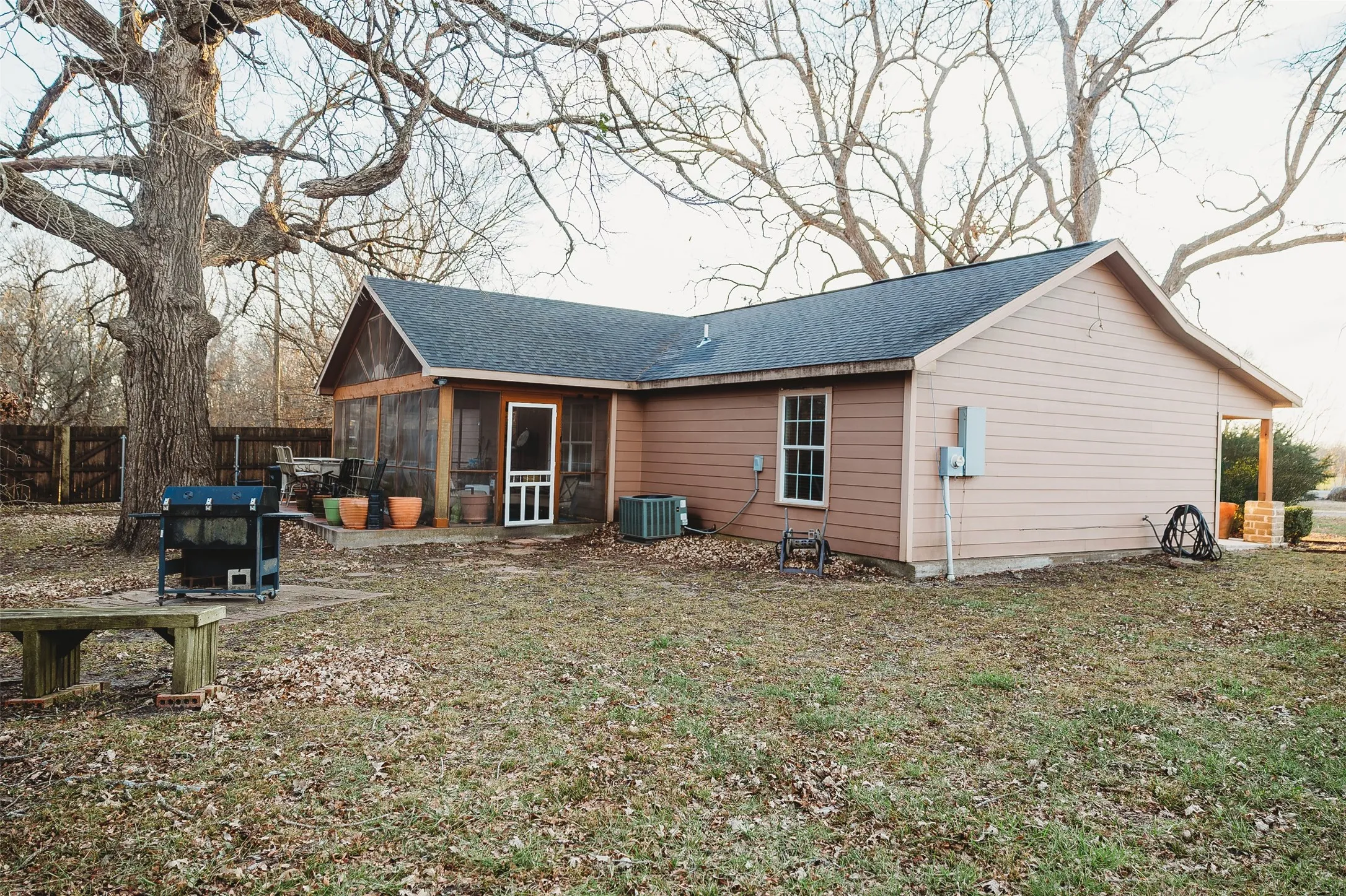 Back of property featuring a sunroom and a shingled roof
