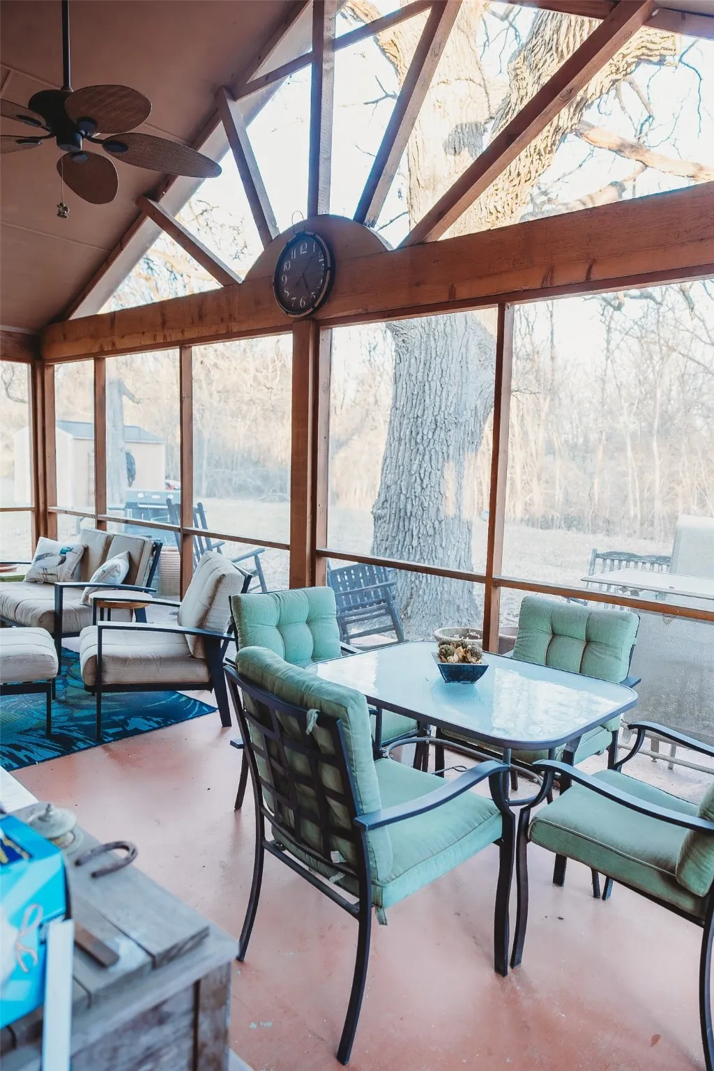 Sunroom with a skylight, high vaulted ceiling, and concrete flooring