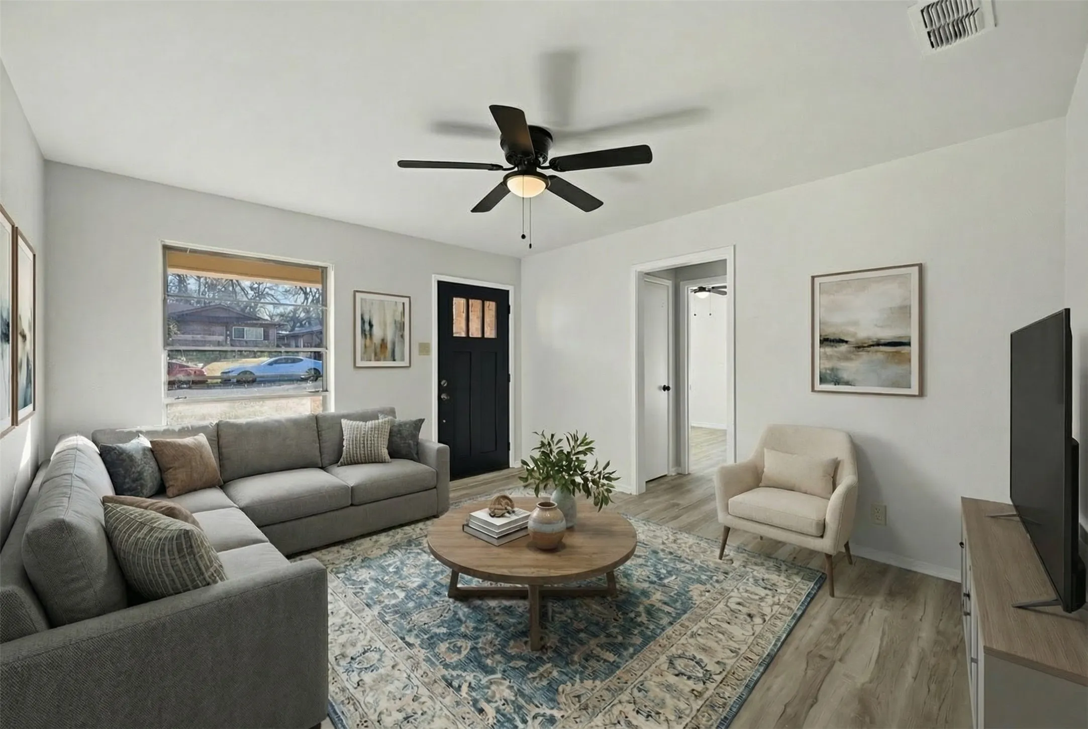 Living area with light wood-type flooring and a ceiling fan