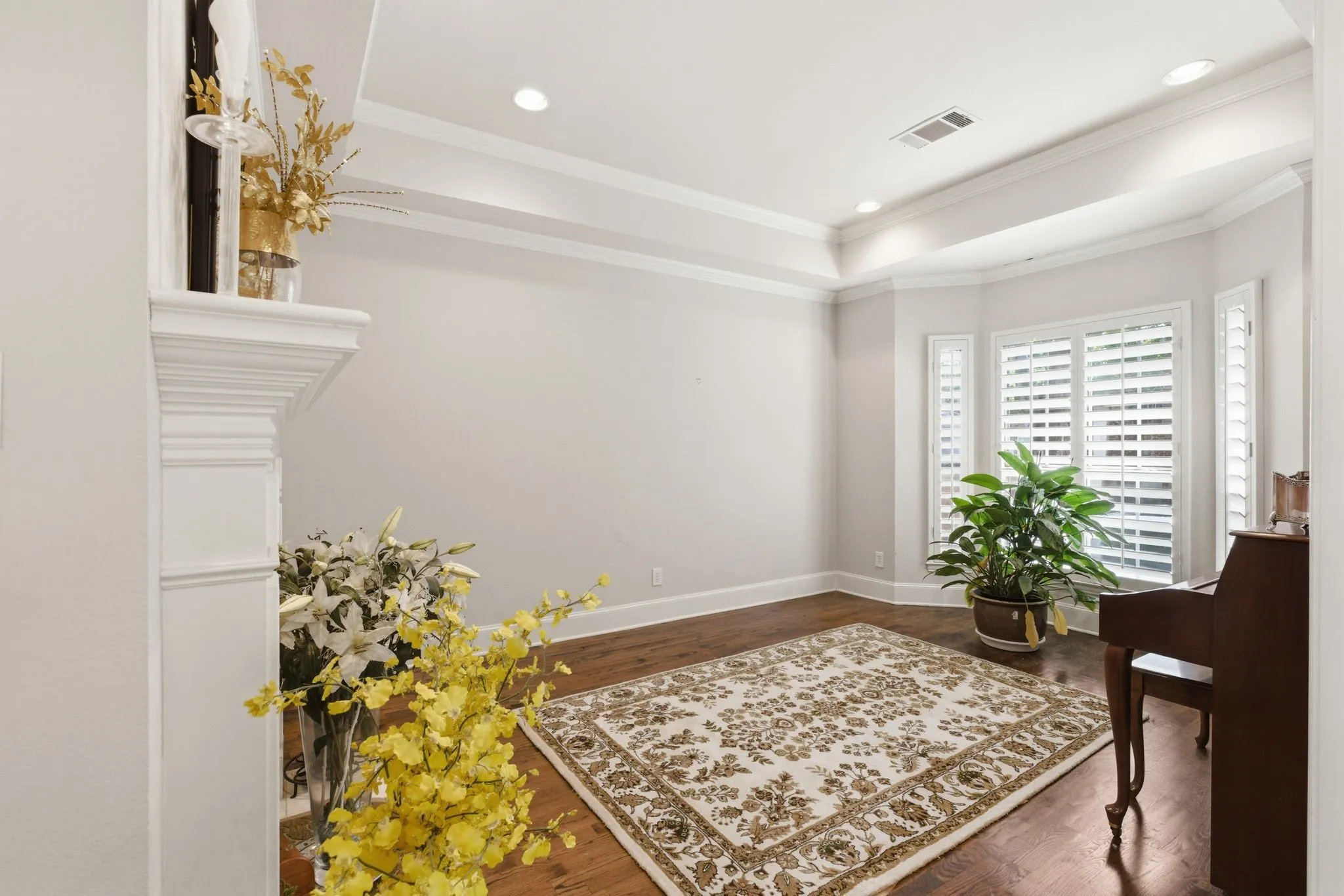 Living area featuring dark wood floors, a tray ceiling, recessed lighting, and ornamental molding