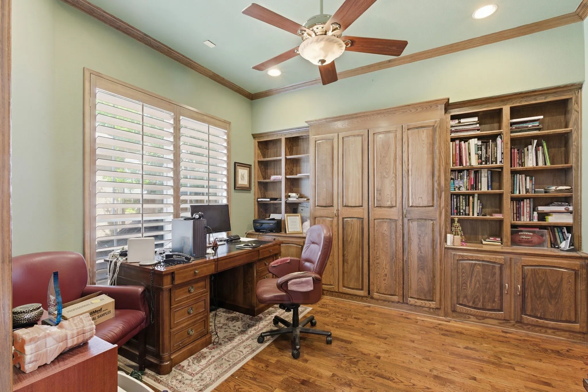 Office area featuring ceiling fan, light wood-style floors, ornamental molding, and Cabinet Bed and private bathroom