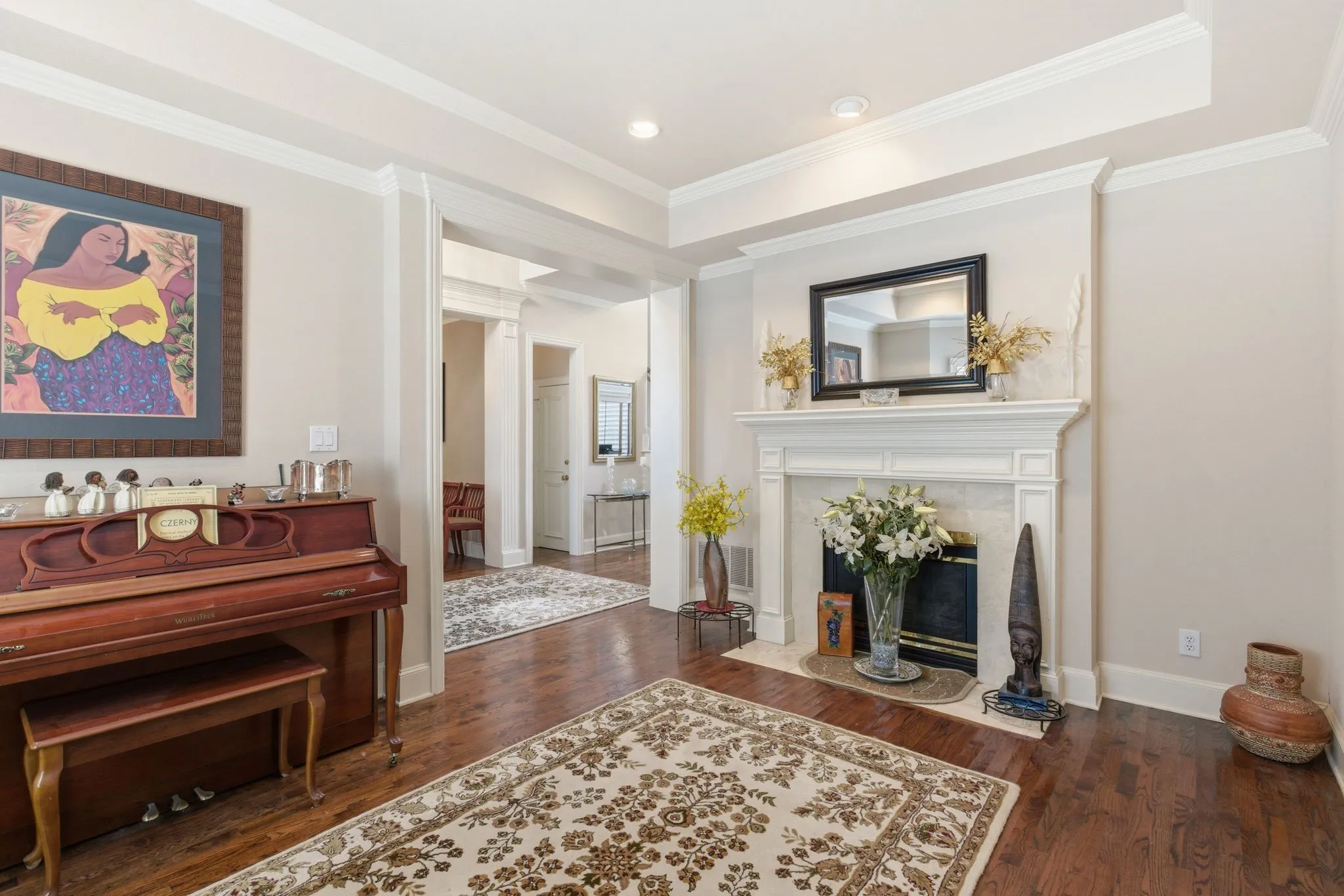 Living room featuring dark wood-style flooring, crown molding, and a fireplace, Wood Shutters
