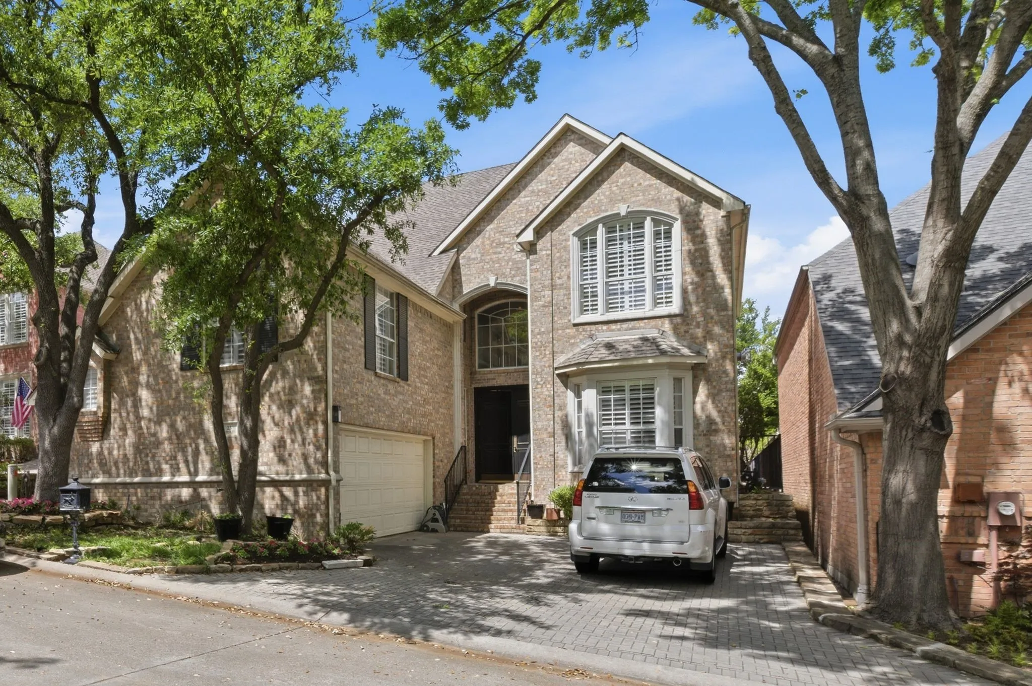View of front of home with brick siding, driveway, and an attached garage