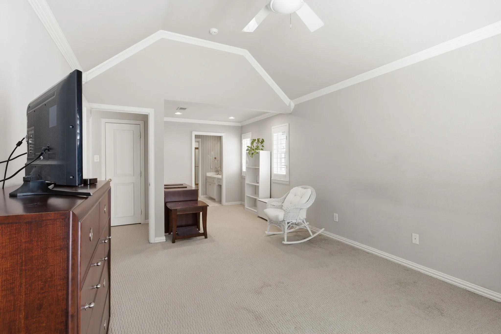 Study area with crown molding, light carpet, and a ceiling fan