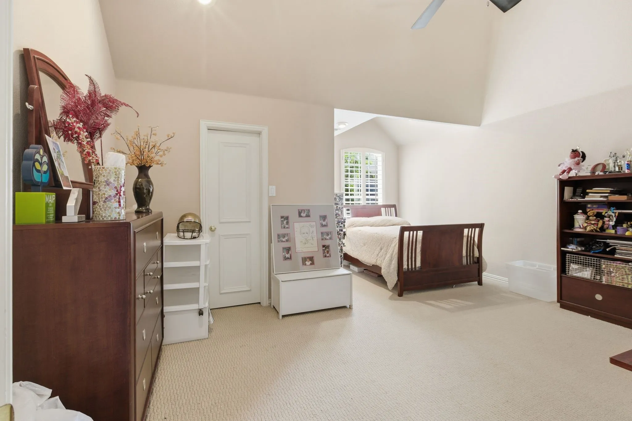 Bedroom with light colored carpet, lofted ceiling, and a ceiling fan