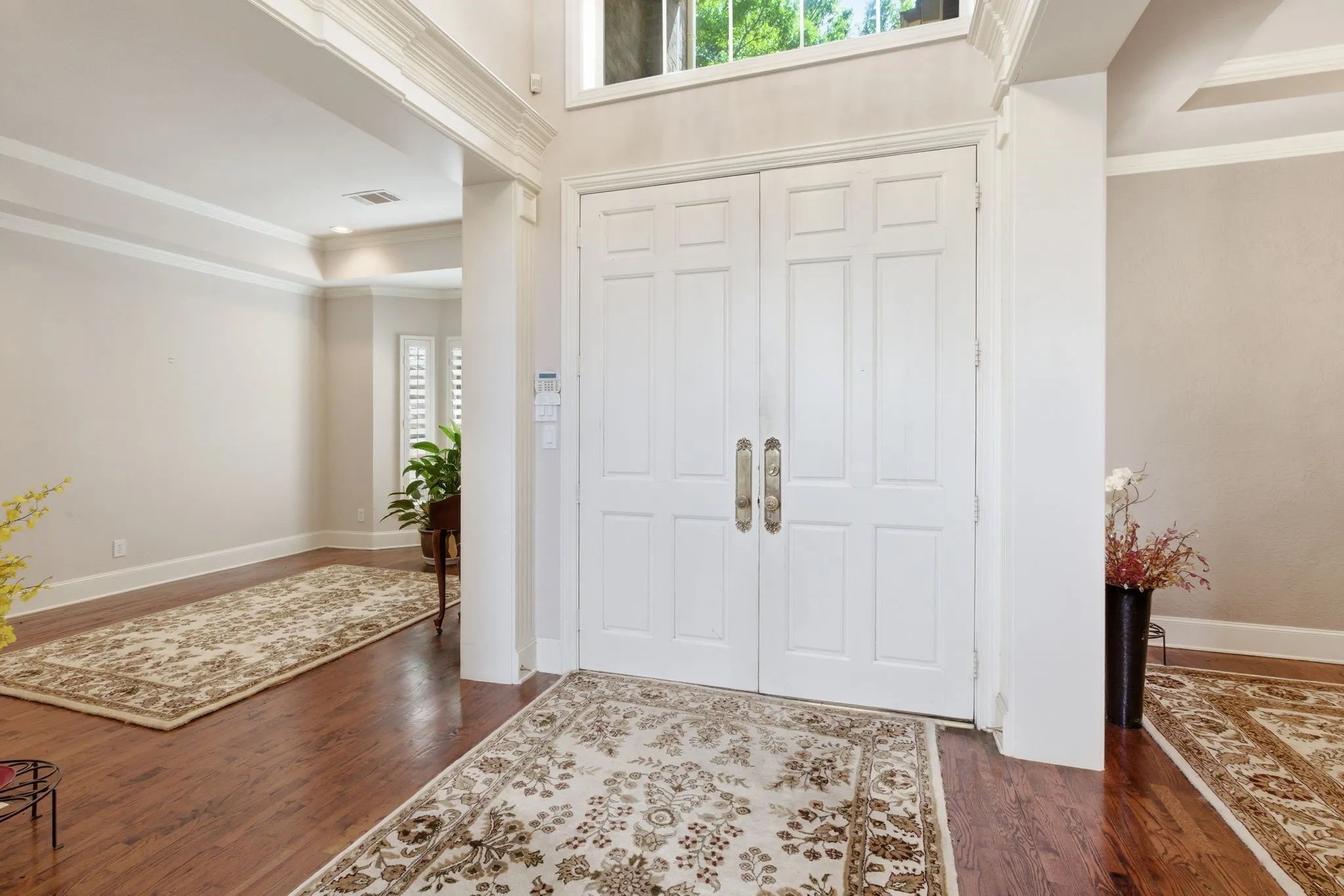 Foyer featuring crown molding, dark wood floors, and a tray ceiling