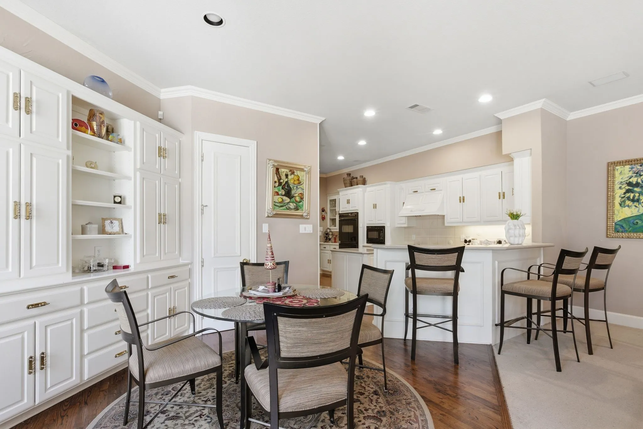  Breakfast area featuring custom Built-in cabinet, molding, recessed lighting, and dark wood flooring, Pantry entry