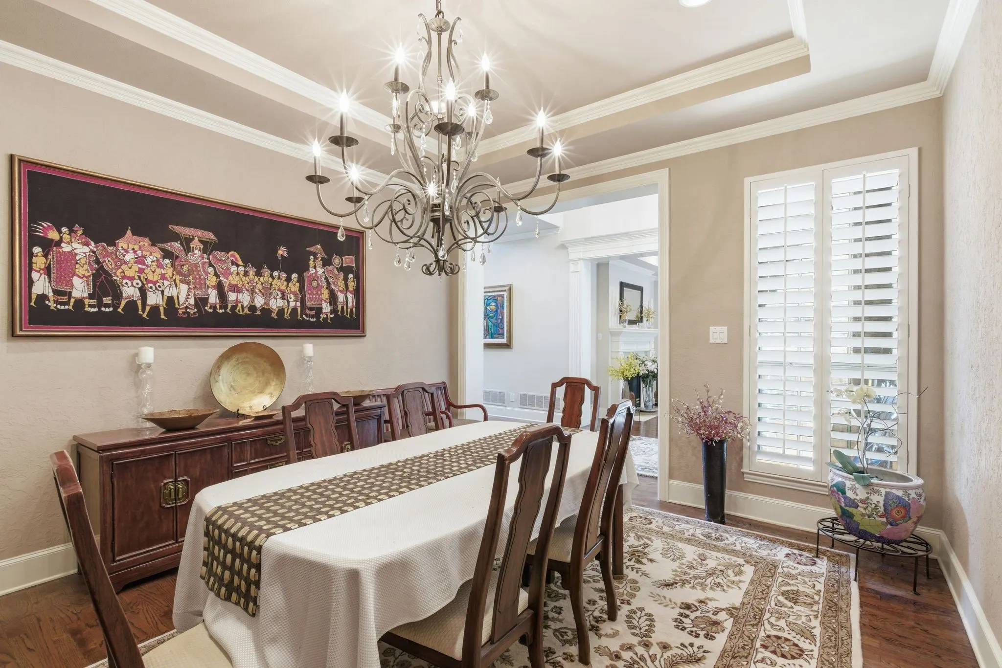 Dining room featuring dark wood-style flooring, hanging lights, ornamental molding, and a tray ceiling high celings