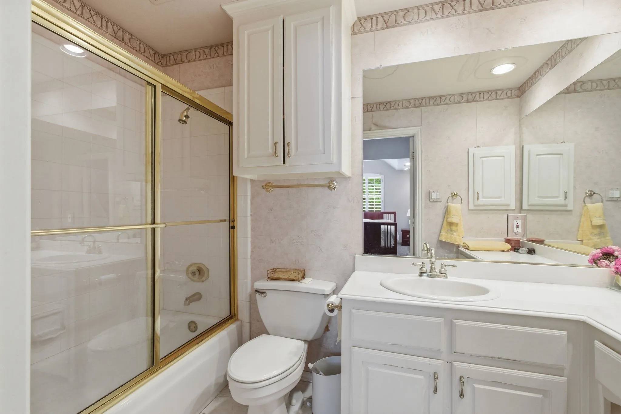 Full bathroom with vanity, shower / bath combination with glass door, and wallpapered walls