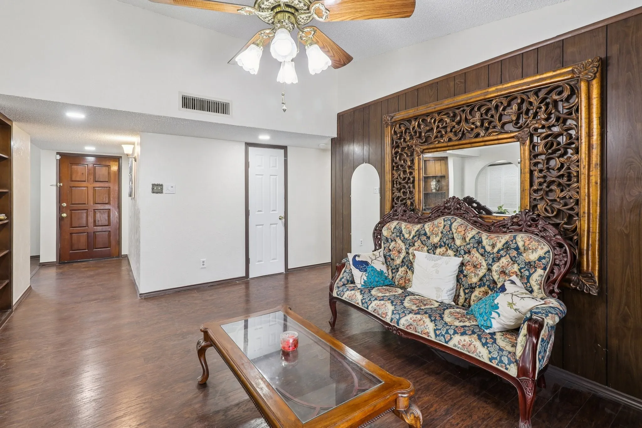 Family room with an accent wall featuring wood paneling. Laminate wood floors.