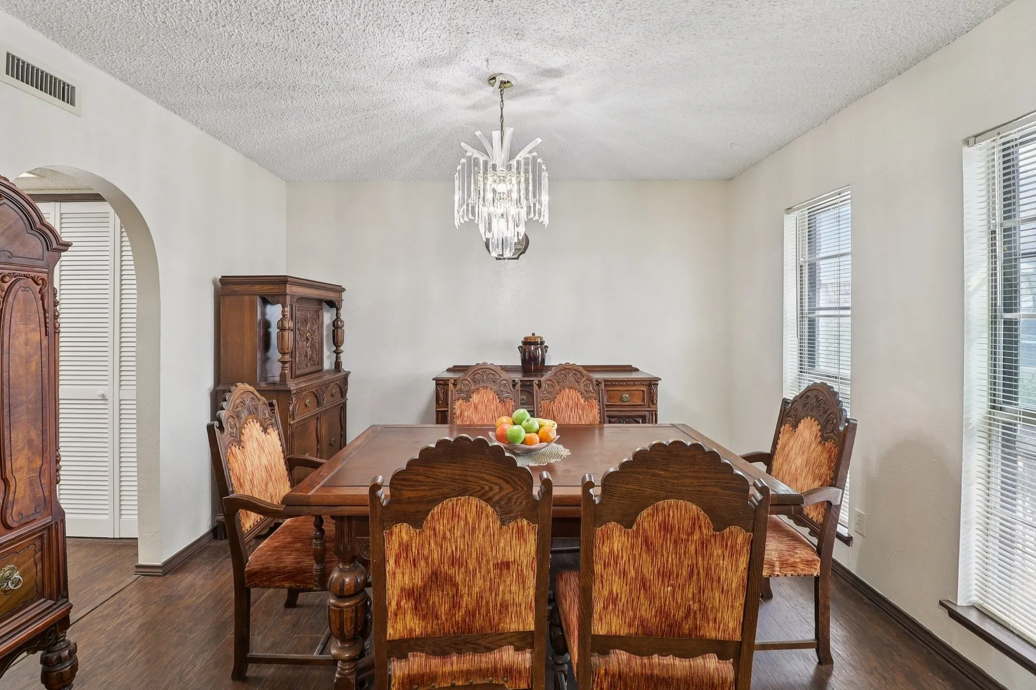 Laminate wood floors. Chandelier and arched doorway to the kitchen.