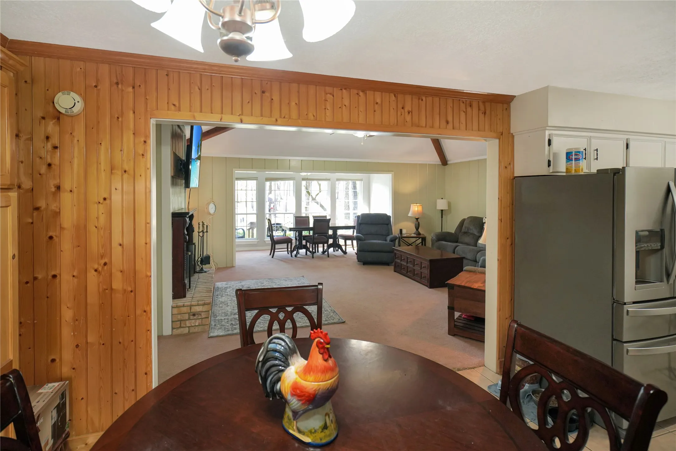 Dining space with ornamental molding, light carpet, and wooden walls
