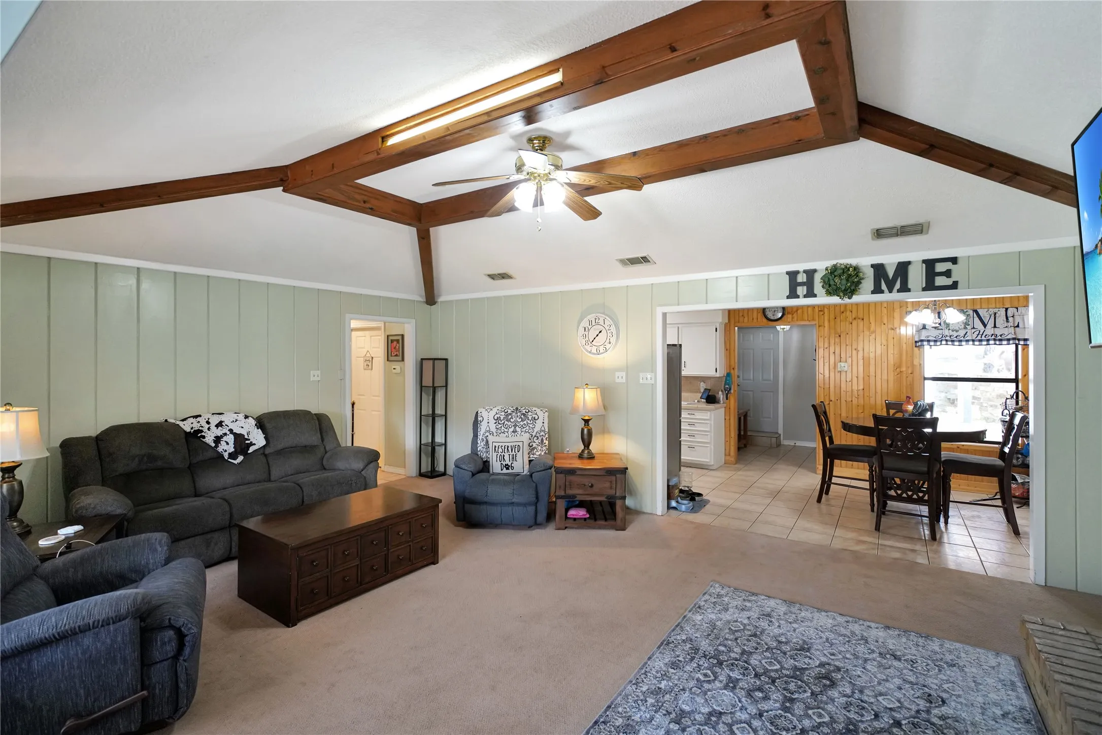 Living room with light colored carpet, ceiling fan, and a chandelier