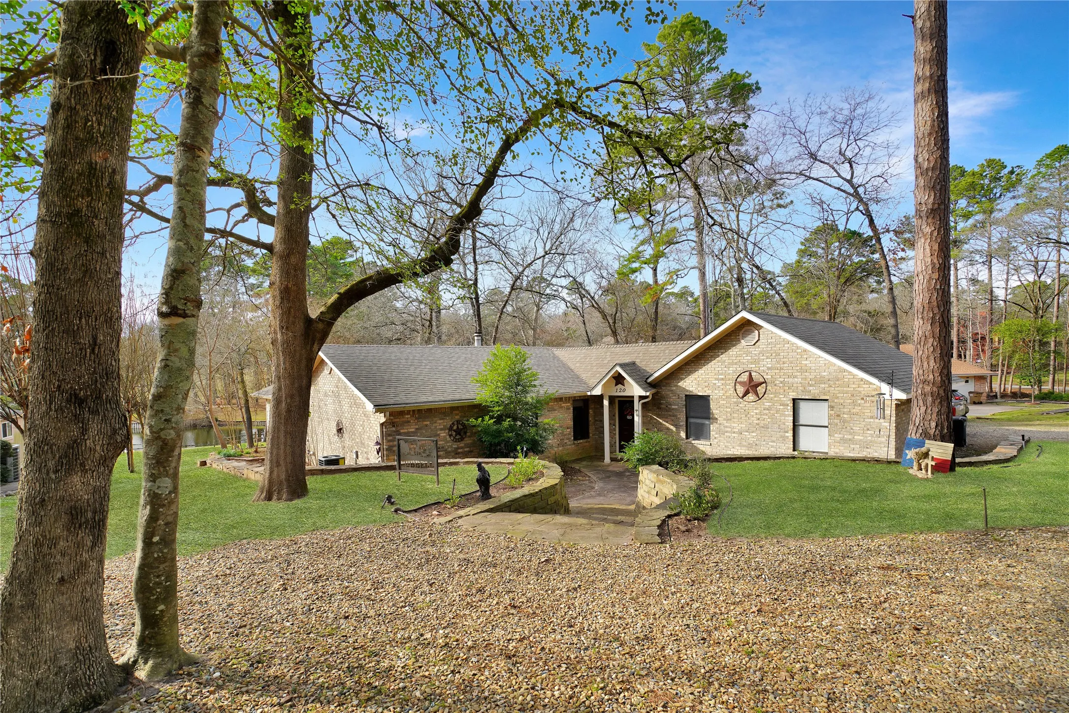 Single story home with a front yard, brick siding, and roof with shingles