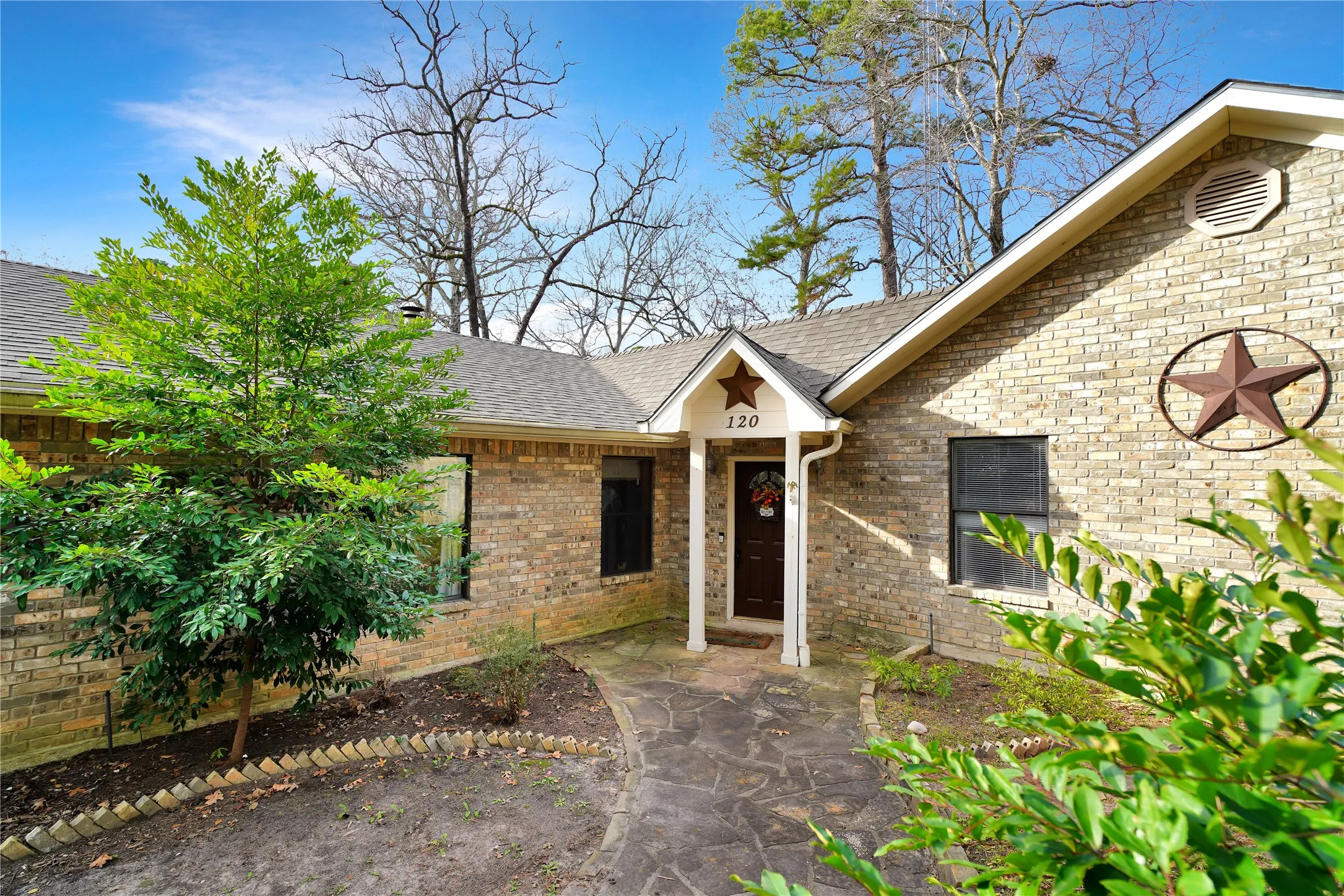 View of front of home featuring brick siding and a shingled roof
