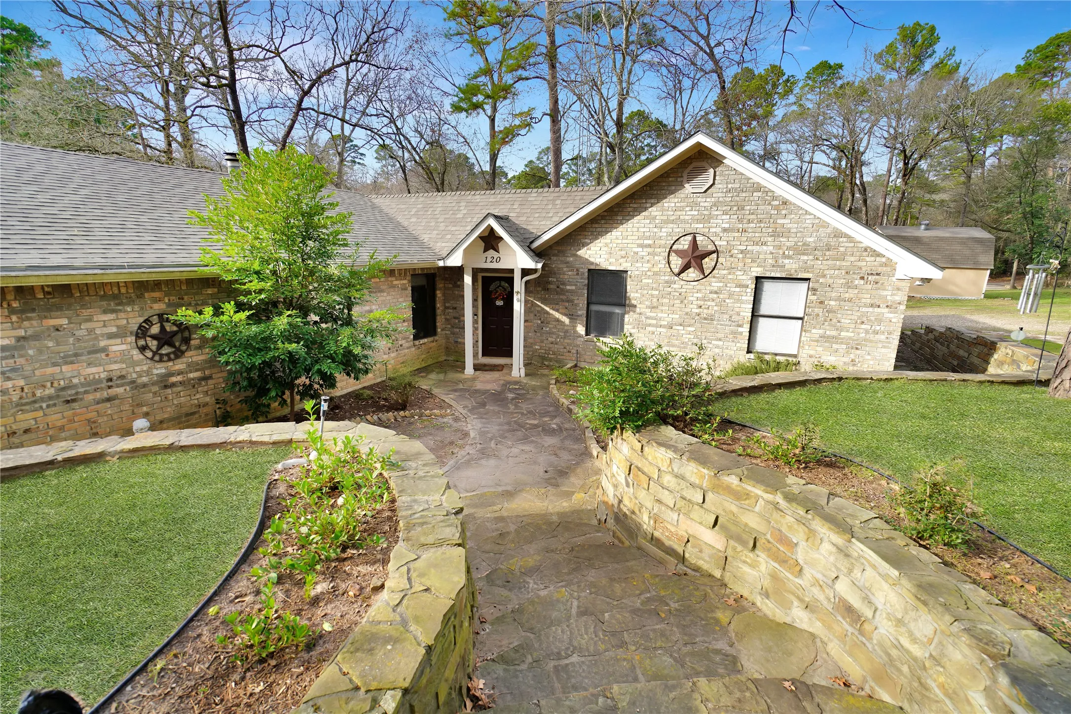Ranch-style home featuring a front yard, brick siding, and a shingled roof