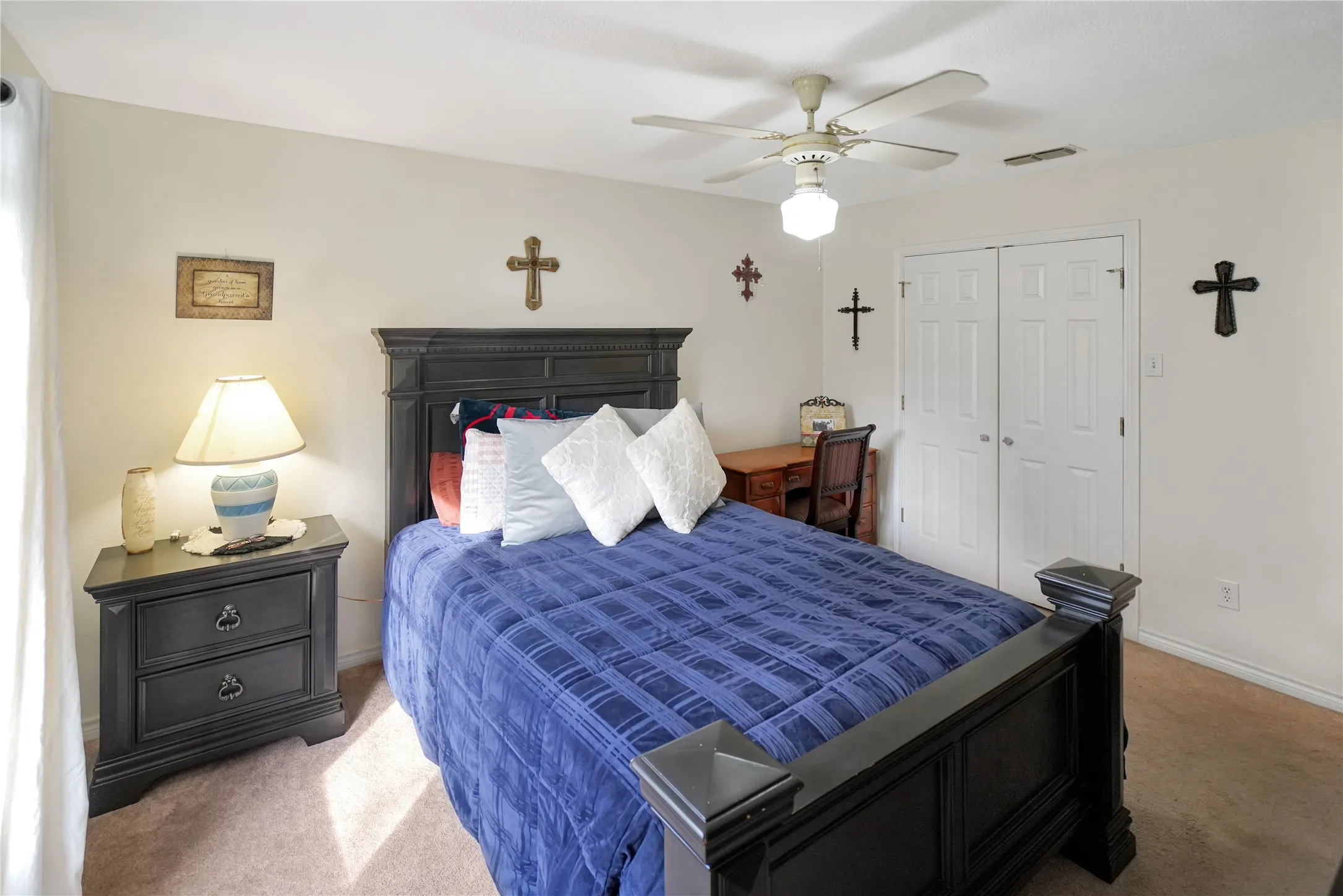 Carpeted bedroom featuring a closet and ceiling fan
