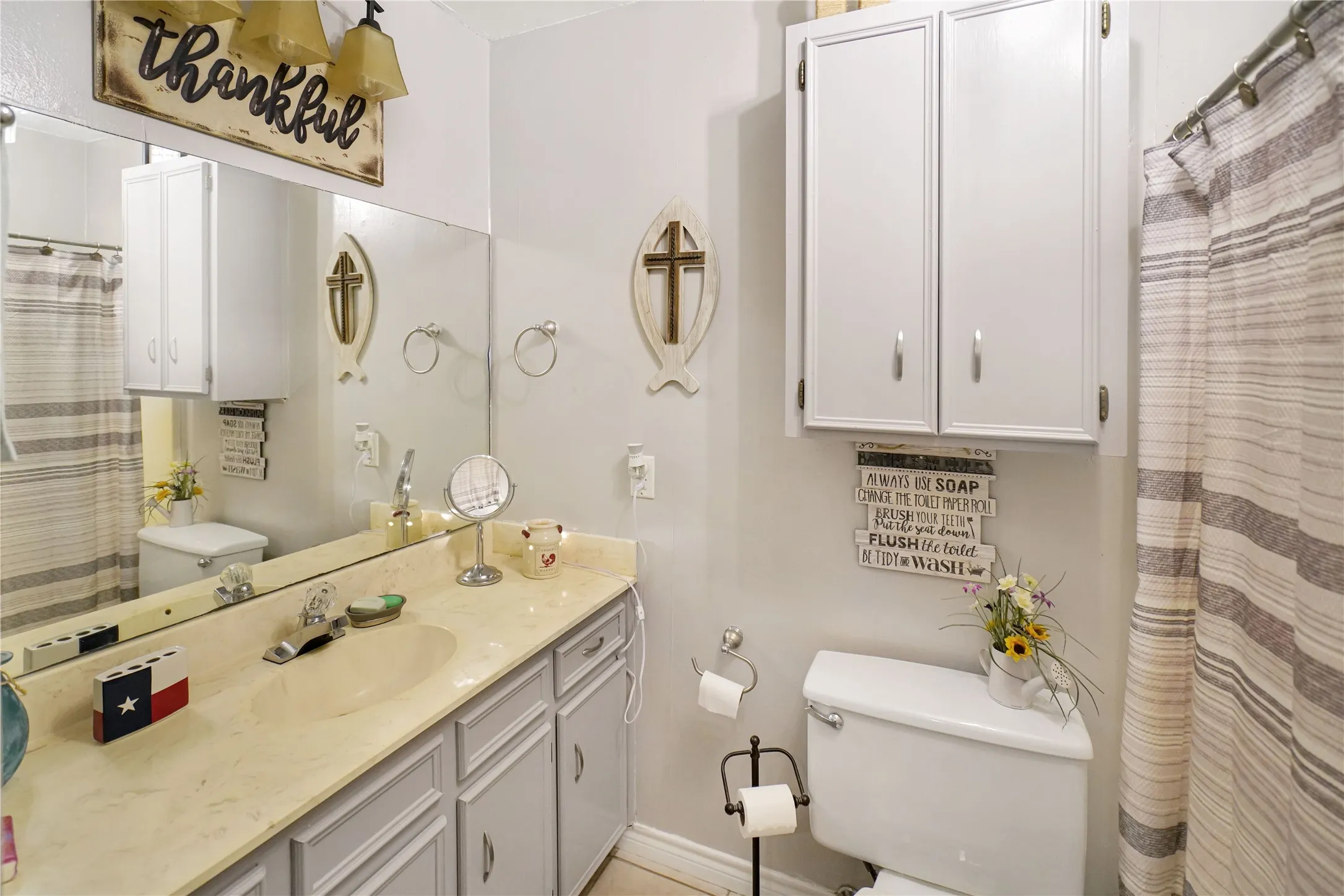 Full bath with curtained shower and vanity