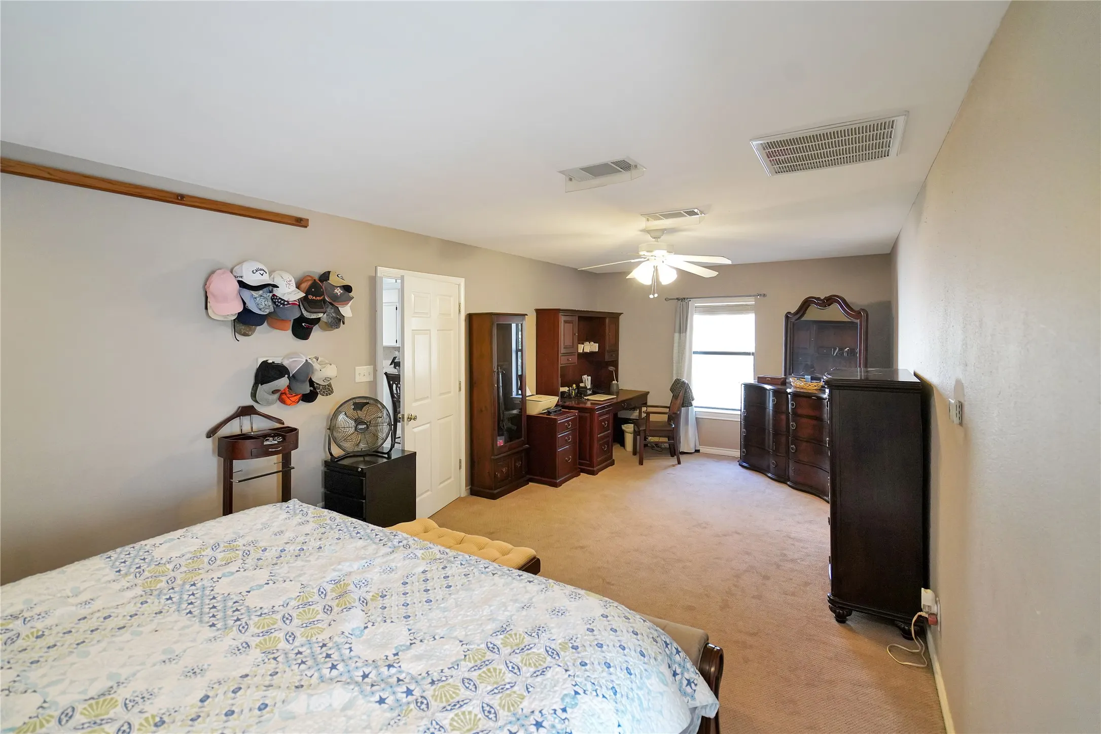 Bedroom with light colored carpet and a ceiling fan