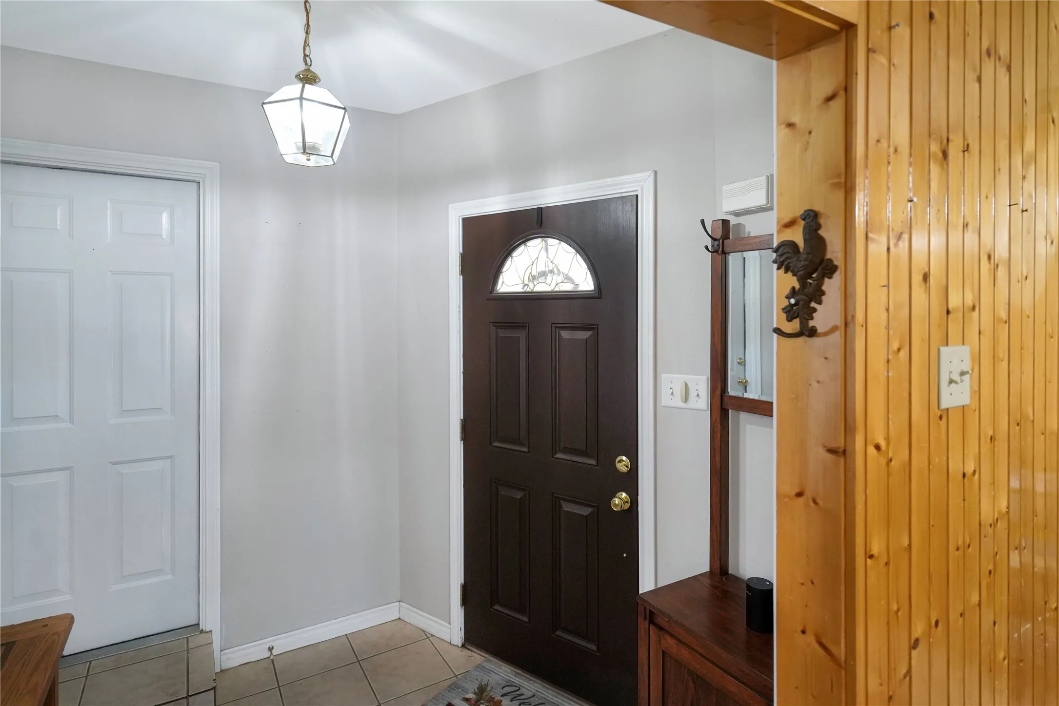Foyer entrance with light tile patterned floors and baseboards