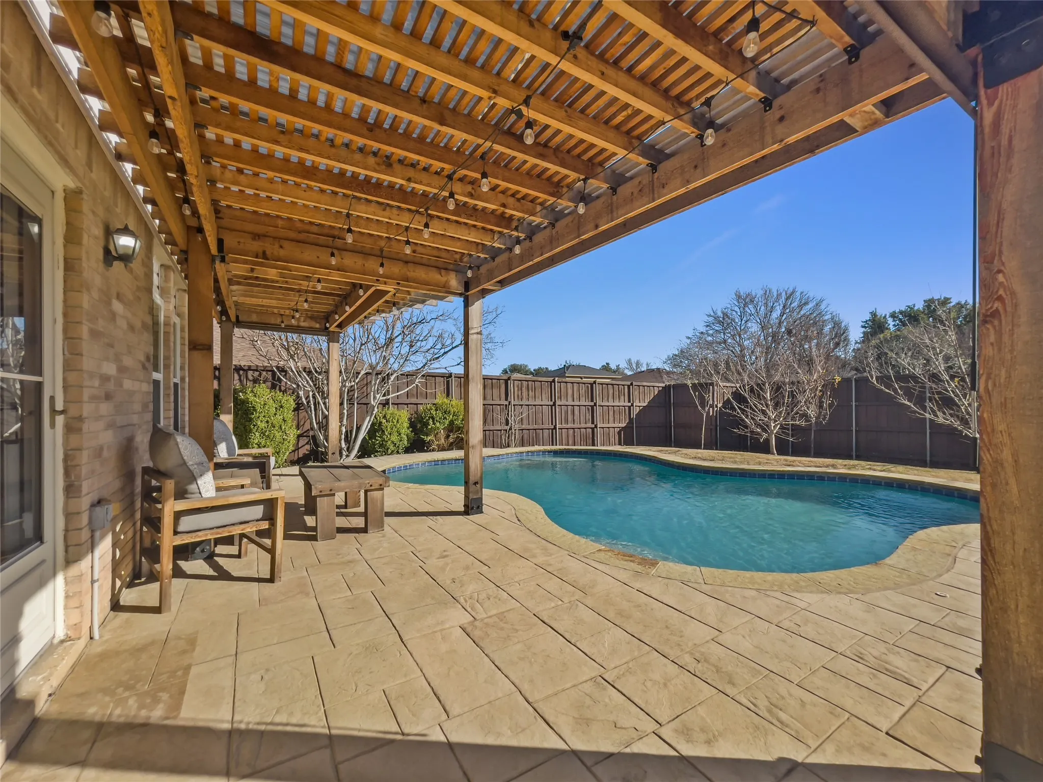 View of pool from under large pergola