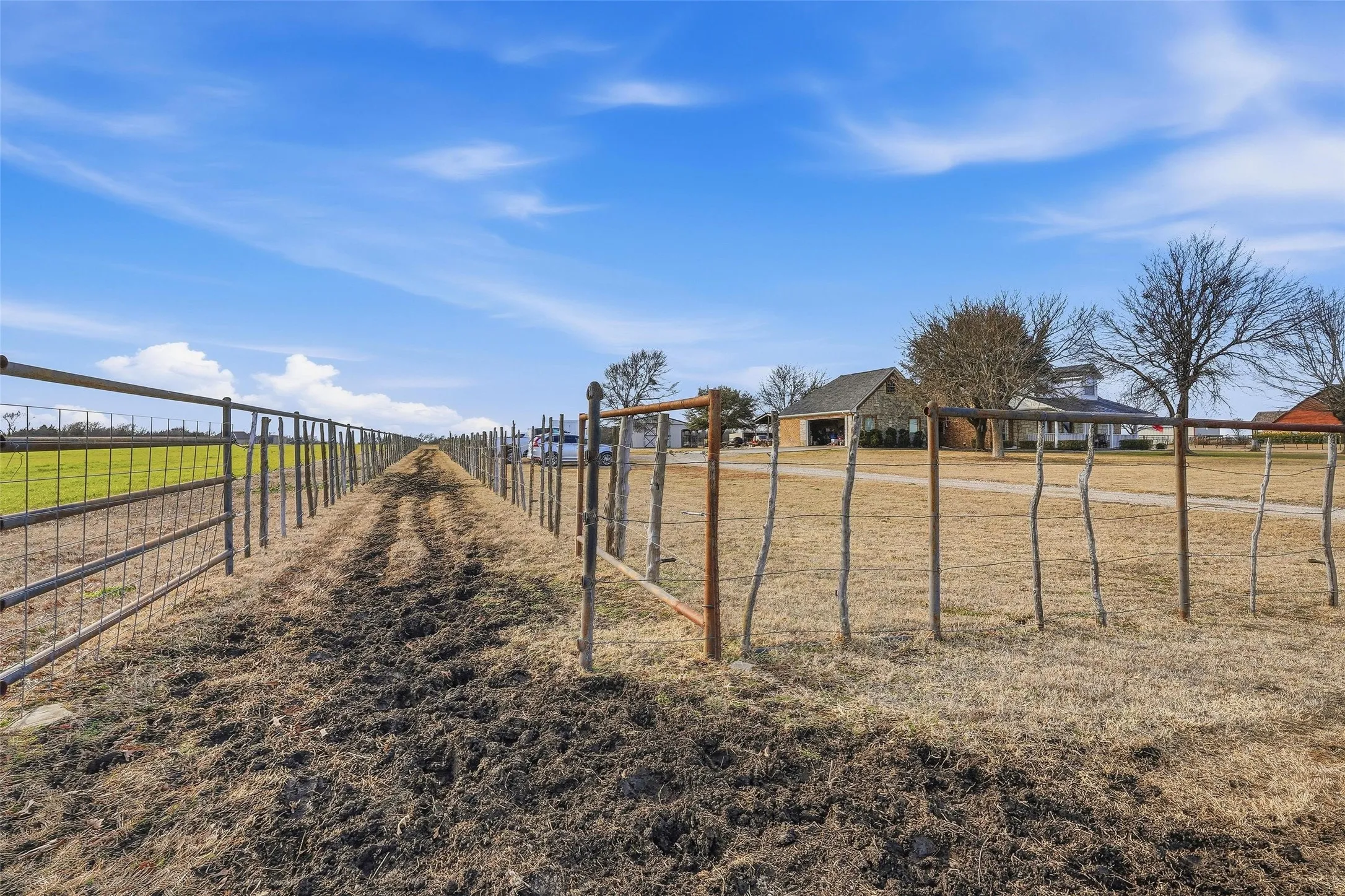 Pipe fencing surrounds the property and includes a livestock run connecting the front and back pastures.