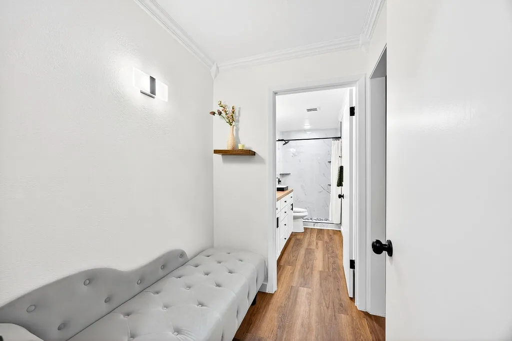 Hall featuring ornamental molding and dark wood-style floors