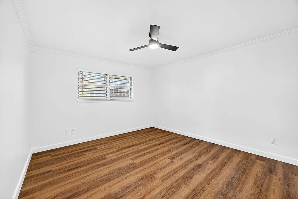 Spare room featuring crown molding and wood finished floors