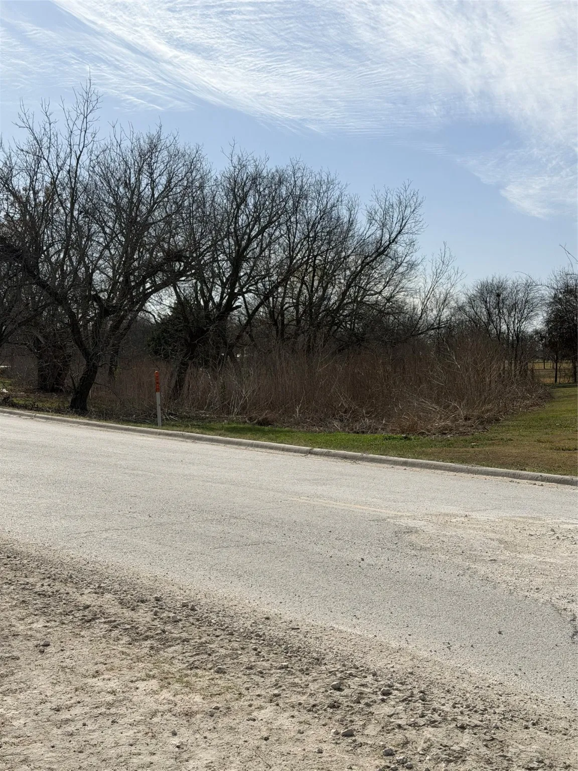 View of asphalt road featuring curbs