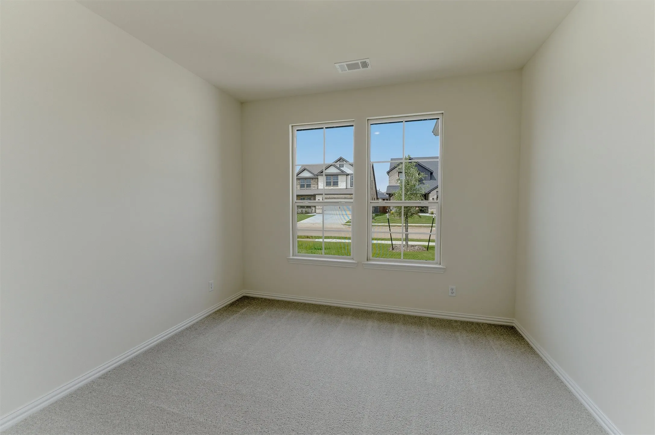 Room featuring light neutral wall paint, white baseboards, and gray carpet