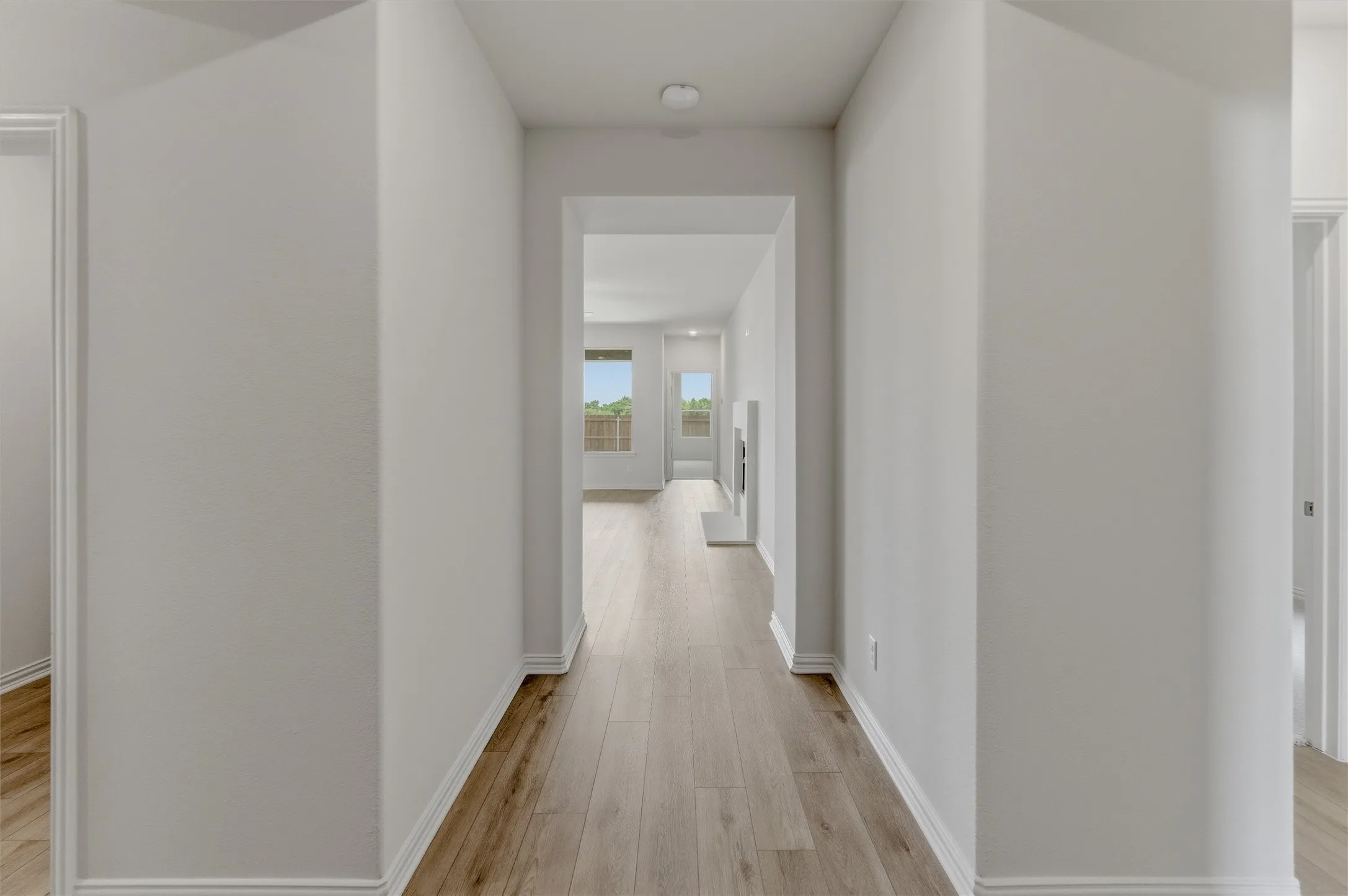 Entry hall featuring wood-finish flooring, white baseboards, and neutral wall paint