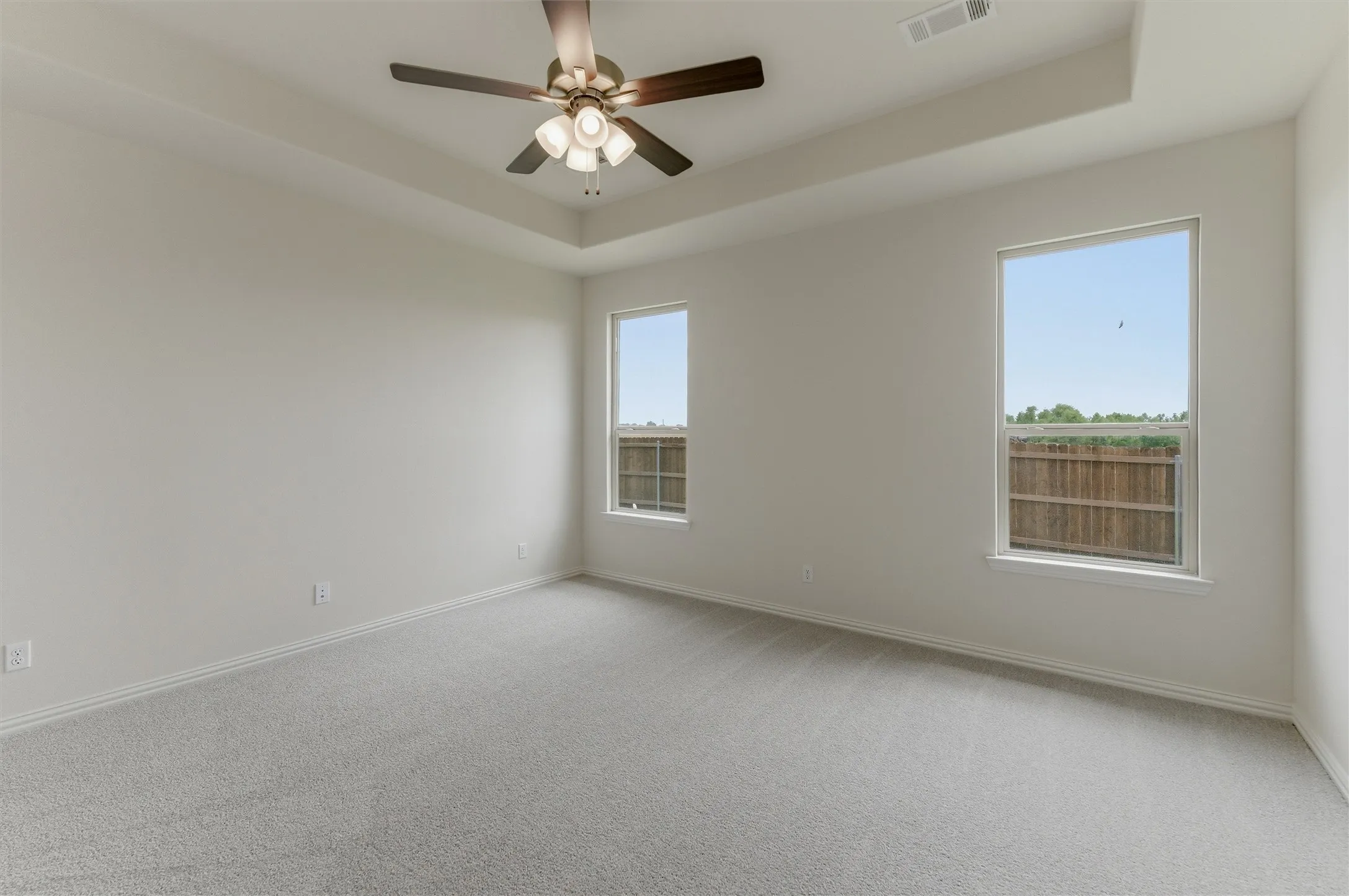 Spacious room featuring light gray carpeting and white walls