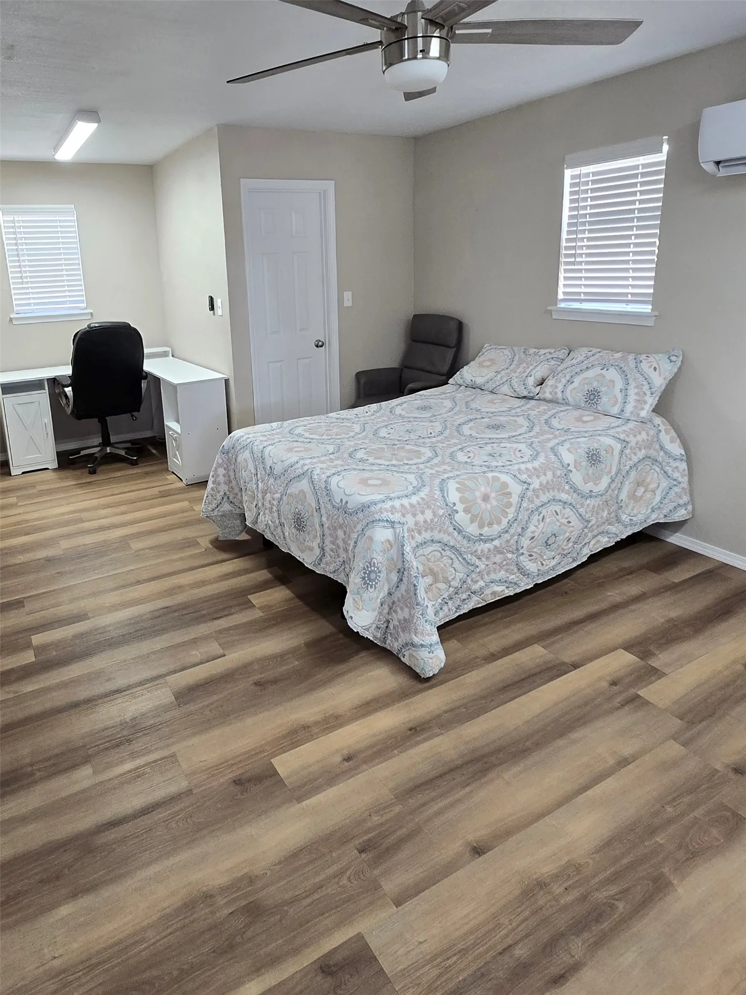 Bedroom featuring an office area, ceiling fan, and dark wood-type flooring