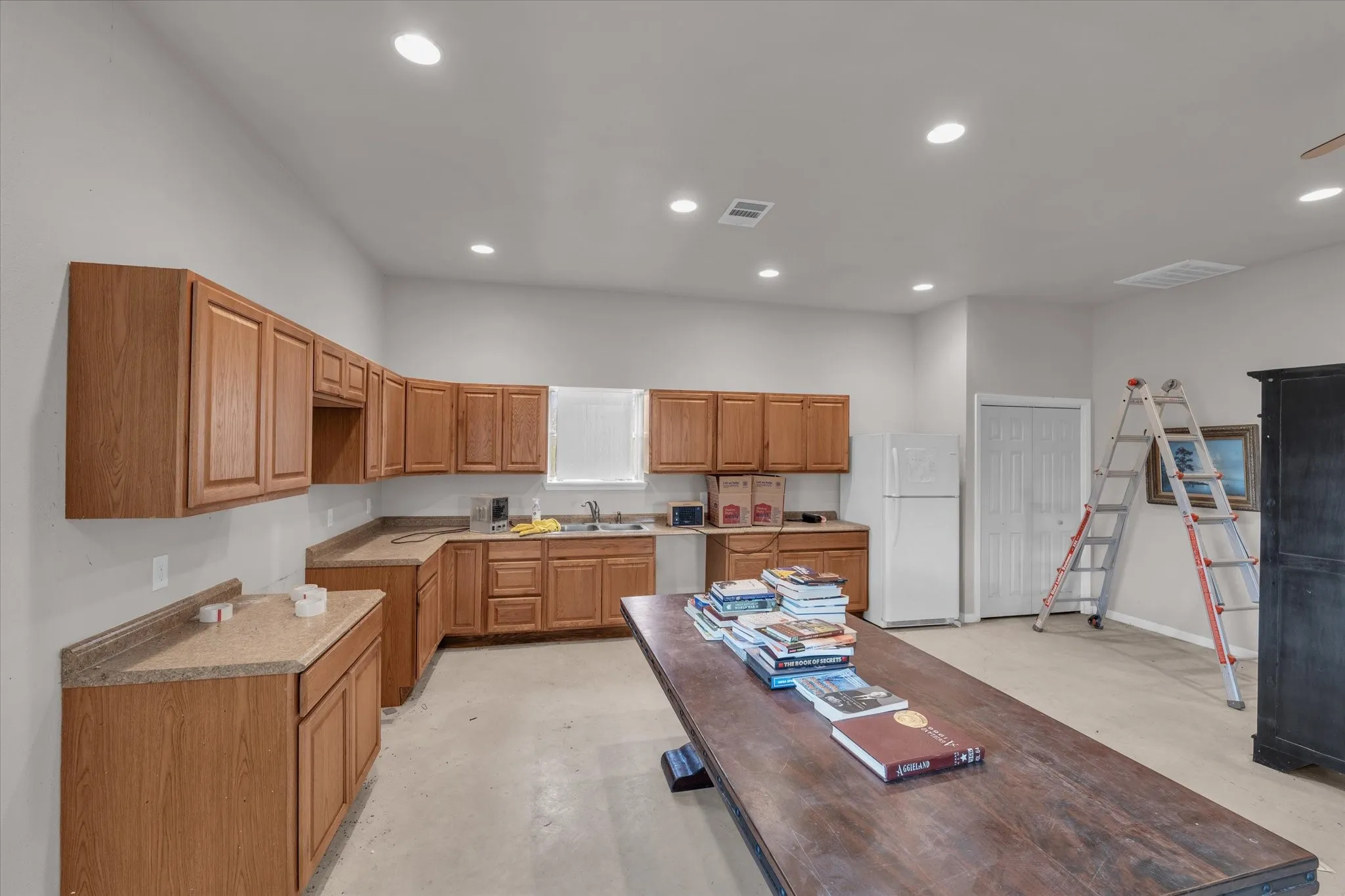Kitchen located in workshop featuring wood cabinets, recessed lighting, light countertops, and dishwasher
