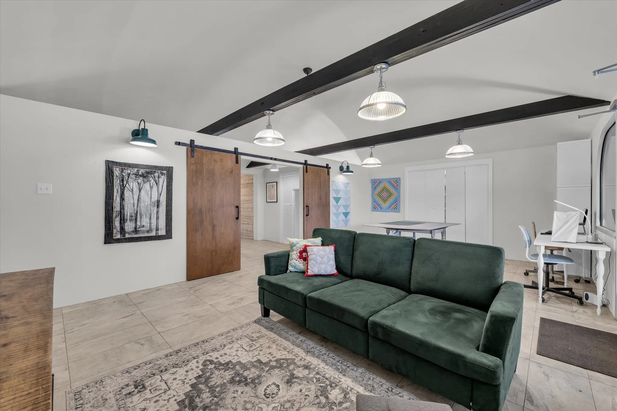 Living room with a barn door and beamed ceiling