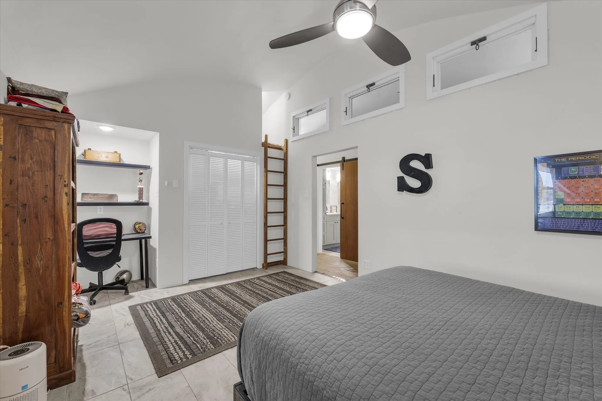 Bedroom featuring a barn door and ceiling fan