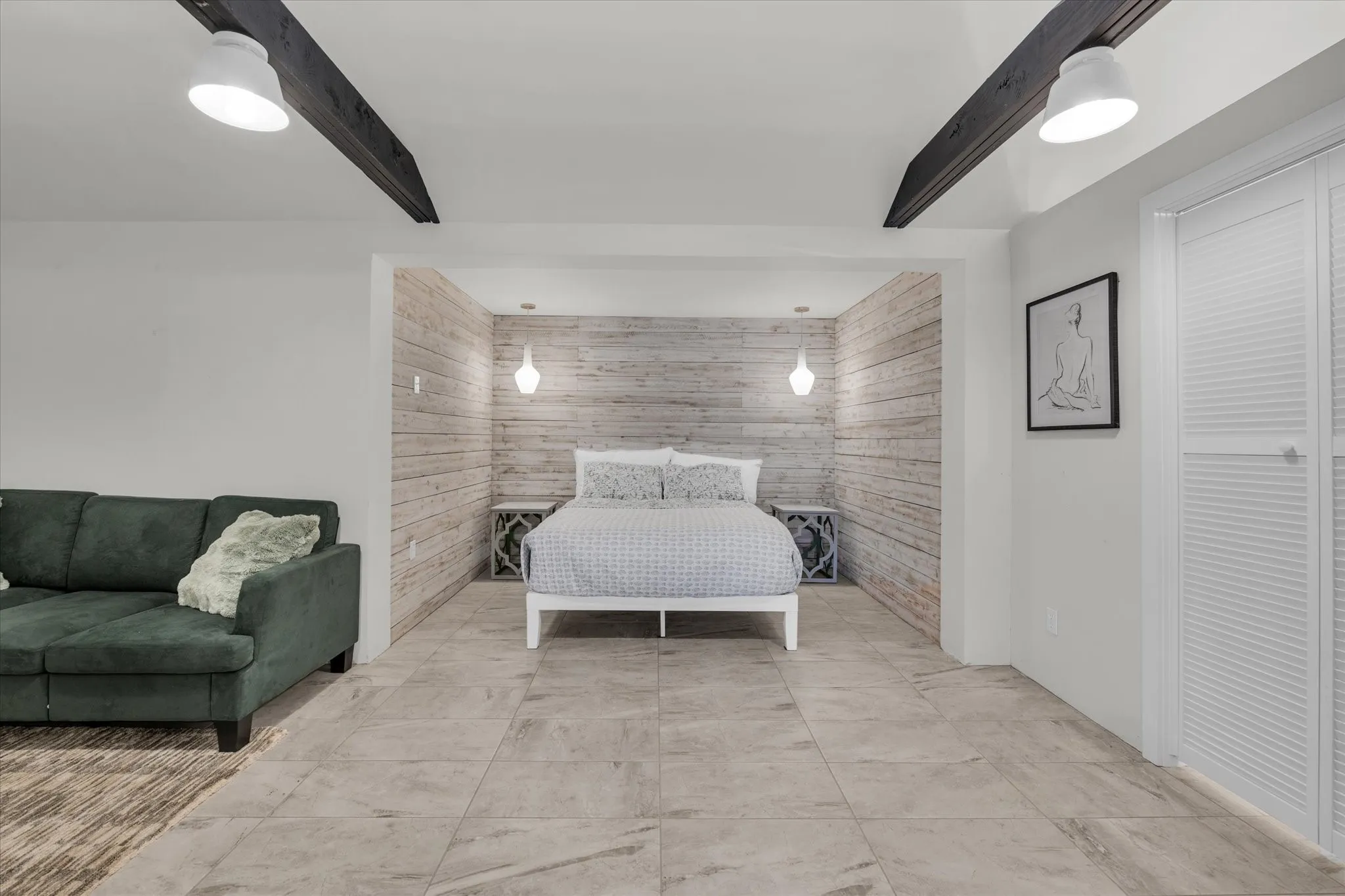 Bedroom with ceiling fan, wooden walls, an accent wall, and a walk-in closet